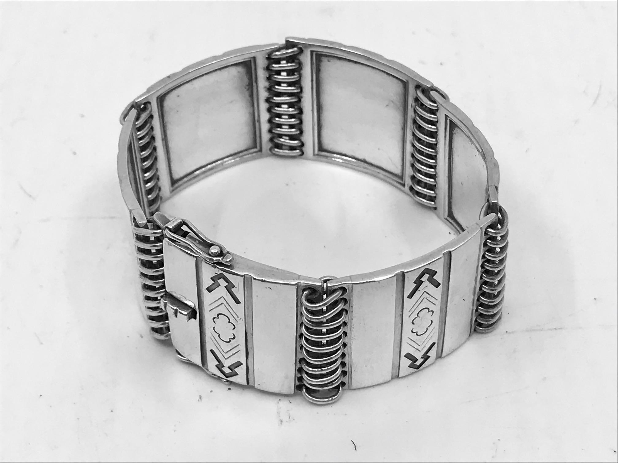 Vintage Sterling Silver Georg Jensen bracelet with Mayan inspired pattern, design #65 by Oscar Gundlach-Pedersen from circa 1931.
Quite a wide bracelet, it Measures 7½” in length, each link is 1″ across (19cm, 2.5cm).
With vintage Georg Jensen