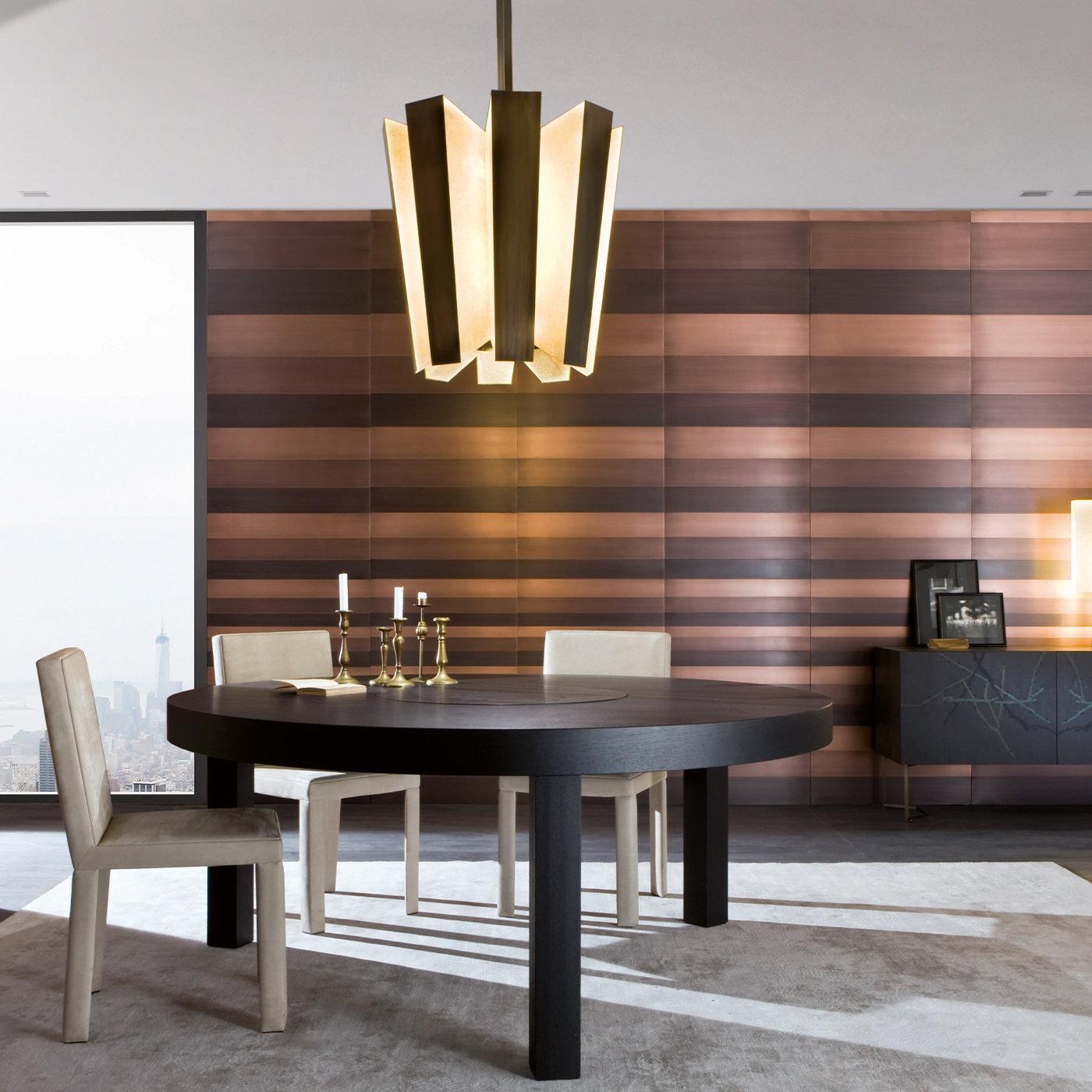 Questa squisita lampada da soffitto si distingue per la sua silhouette unica, a forma di cono tronco e rovesciato, composta da otto elementi. I frontali sono rivestiti in pelle di capra, mentre i lati sono in ottone brunito. Otto strisce LED