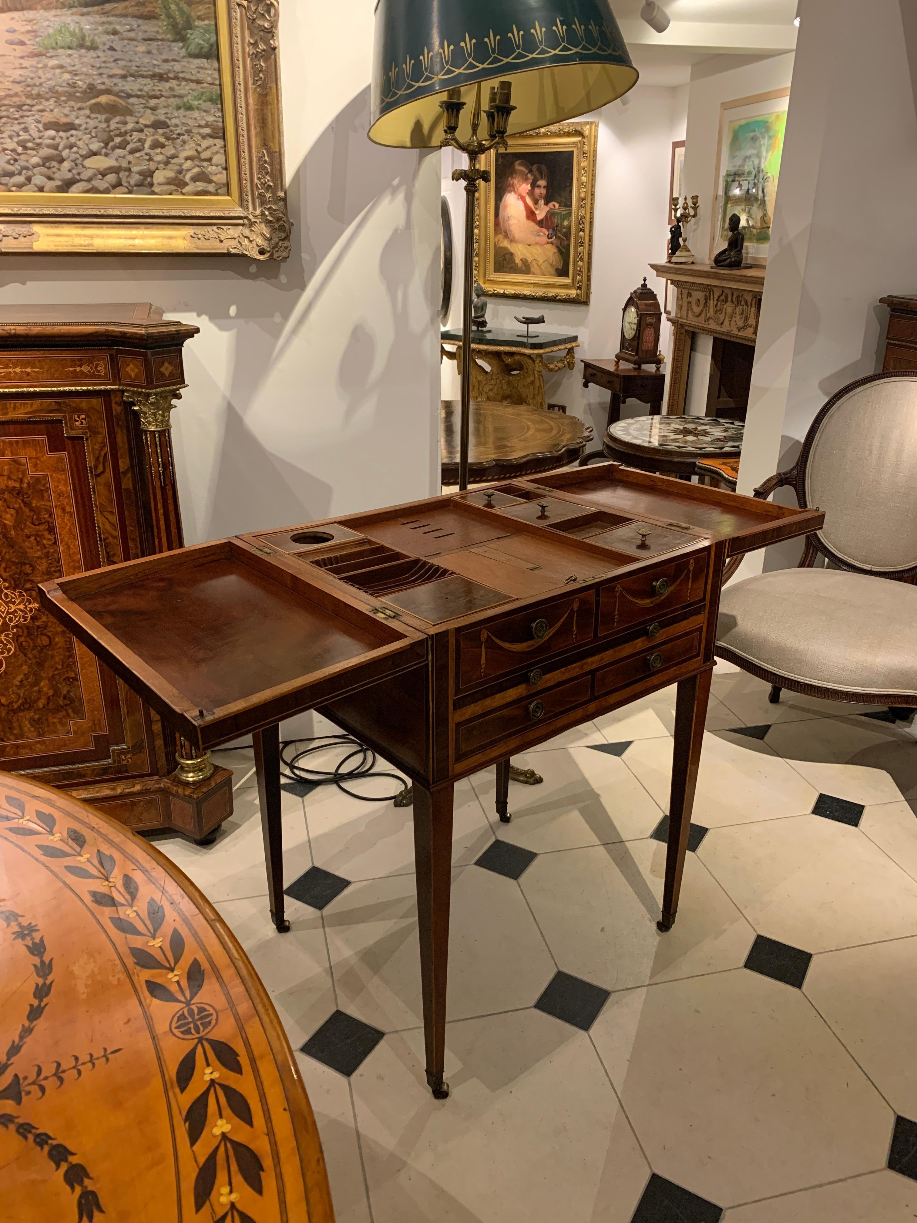Mayhew and Ince style dressing table, on brass wheels. 
Mahogany, satinwood, tulip and box woods, beautiful inlay and details. Inside Burr Yewwood, with mirror.

Late 18th century.