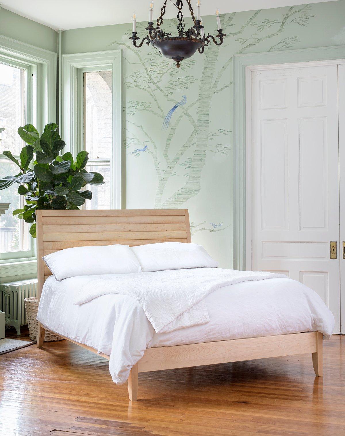 A clean contemporary bed design inspired by Scandinavian Minimalist forms featuring a pillow-shape slatted headboard. Its distinctive overhung bridle joint and tongue and groove slats mark the bed's craftsmanship. Its footboard features an embedded