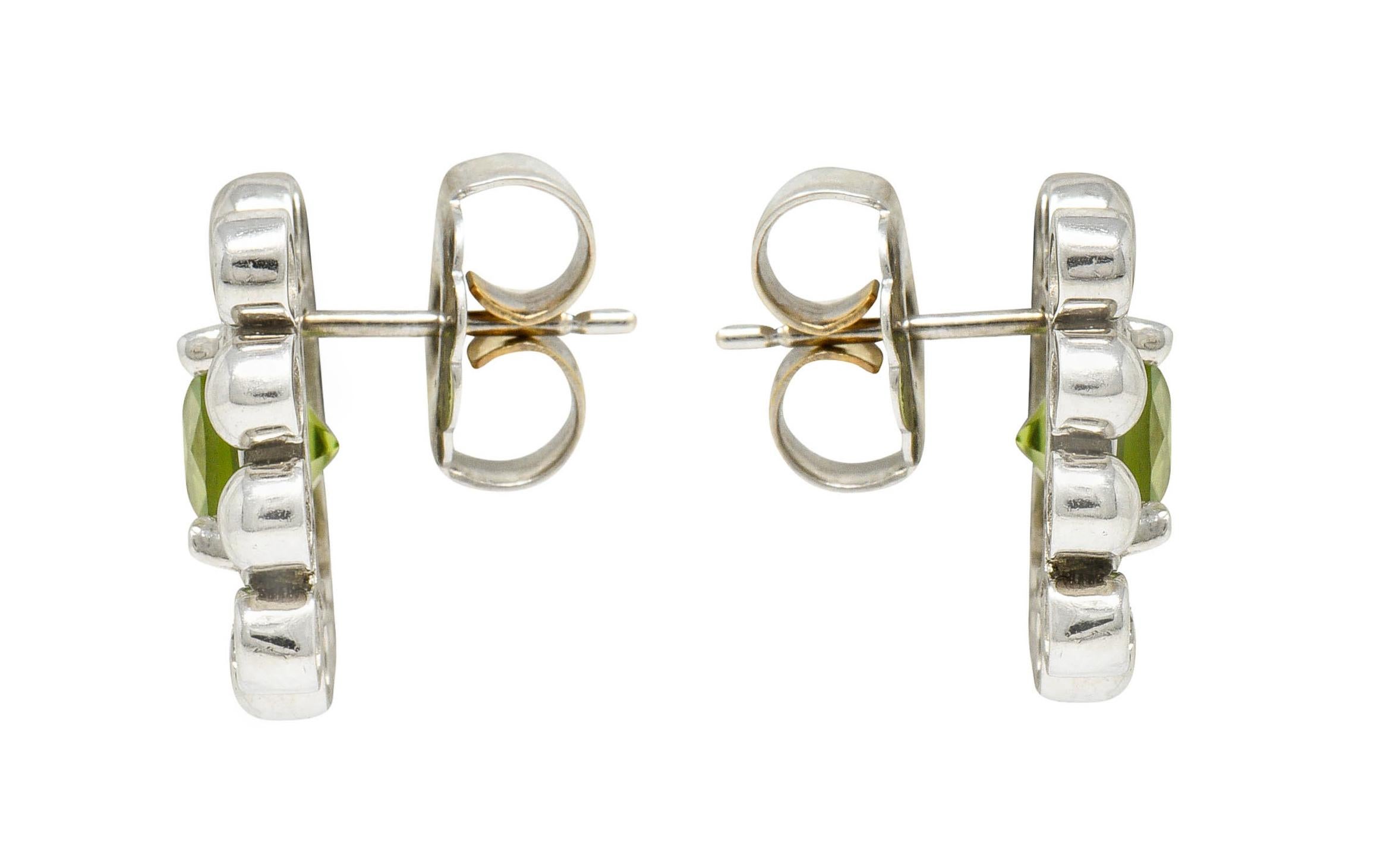 Cluster earrings center cushion cut peridot weighing approximately 3.00 carats

Very well-matched and bright lime green in color

Surrounded by white gold balls and with bezel set round brilliant cut diamonds at each corner

Total diamond weight is