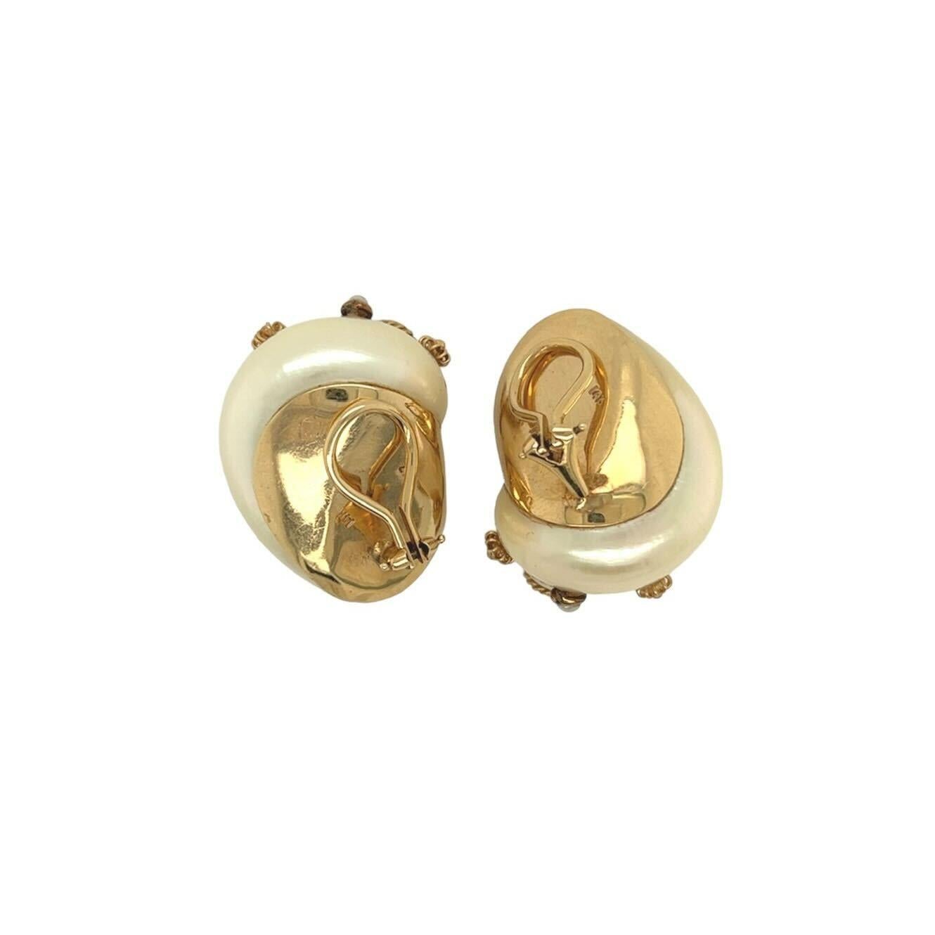 A pair of 14 karat yellow gold, shell and pearl earclips, Maz.  Each earclip designed as an iridescent white turbo shell applied around the spiral with ropework wire, three (3) bezel set seed pearls, three (3) gold rosettes, a bezel set half pearl