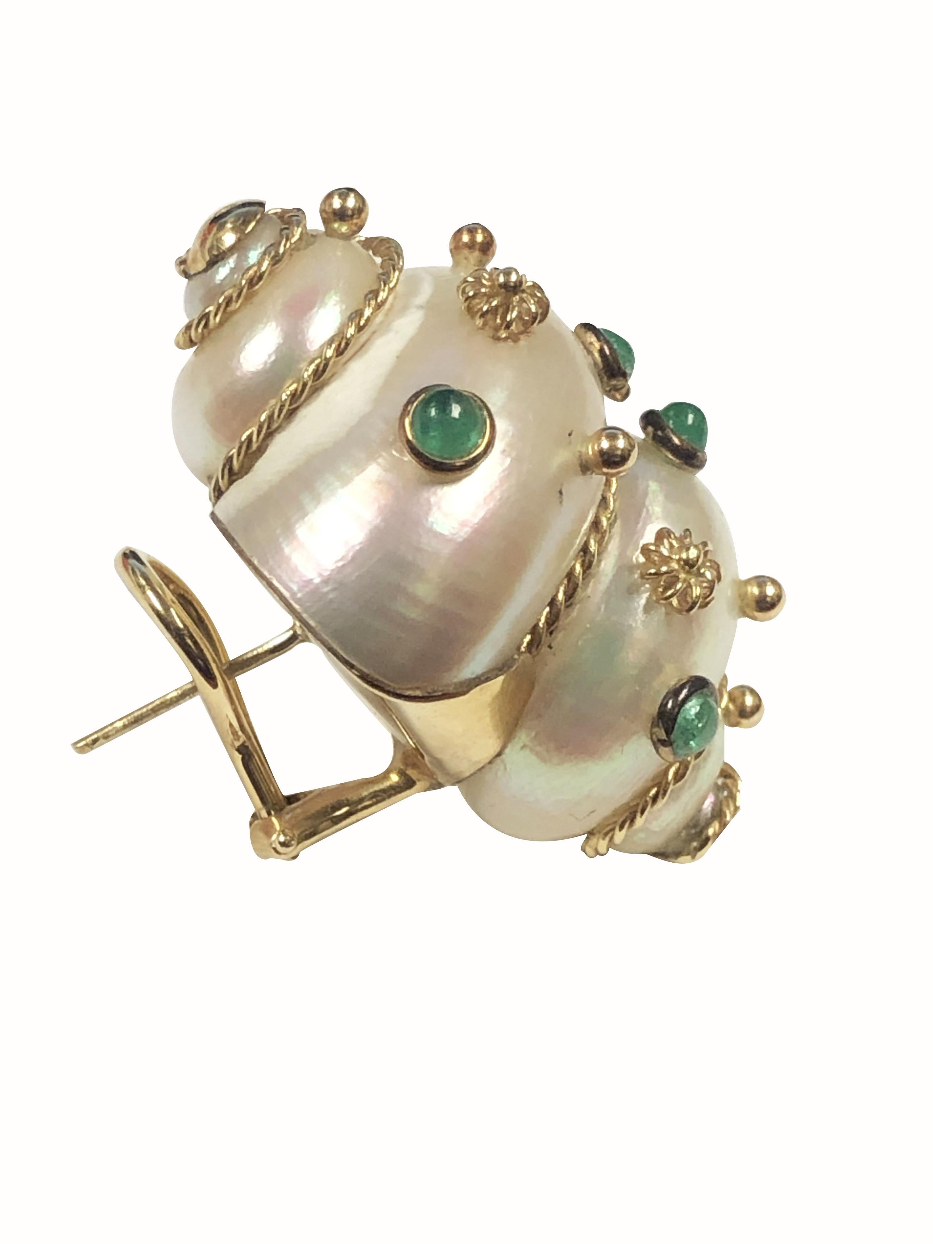 Circa 2000 Maz Turbo Shell Earrings, measuring 1 1/4 inches in length X 7/8 inch wide, 14K Yellow Gold backed and also having bezel set Cabochon Emeralds and further decorated with Gold accents. Omega clip backs with a post.
