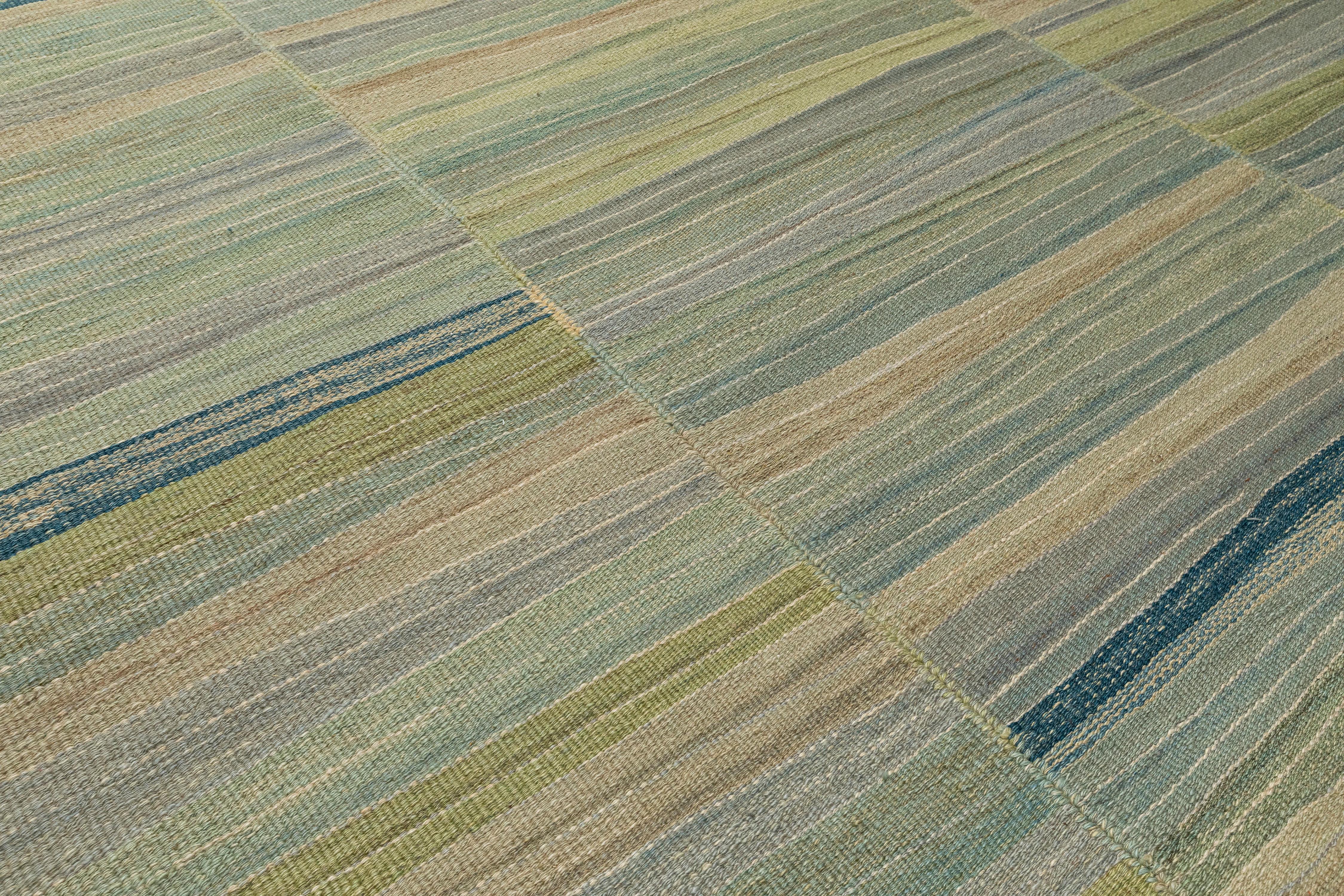 Questo tappeto contemporaneo Mazandaran kilim a tessitura piatta è un pezzo forte di Nasiri Carpets, realizzato con lana filata a mano e tinto con tinture naturali a base vegetale. Con i suoi toni delicatamente stratificati di verdi, blu e neutri,