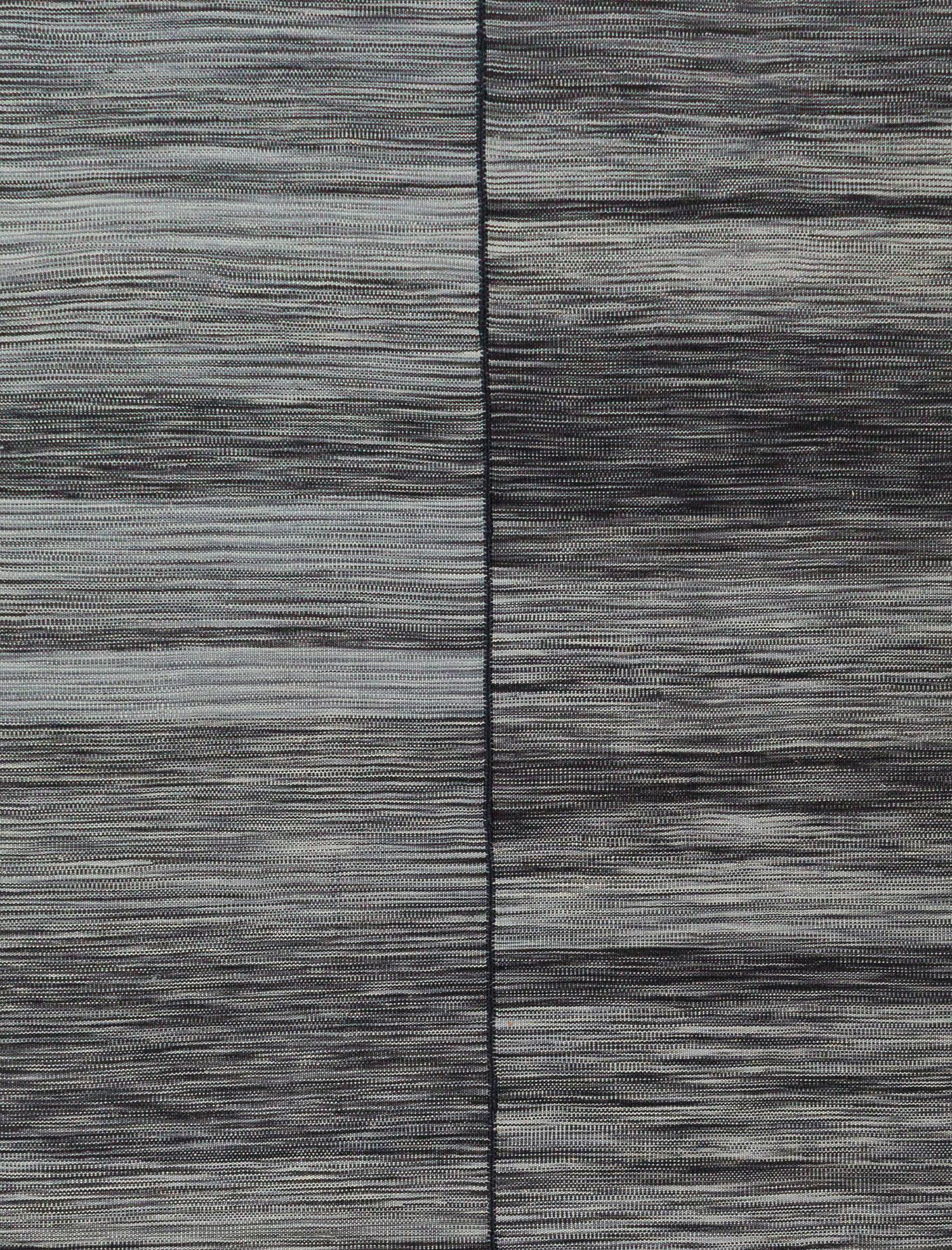 Dieser wunderschöne Flachgewebeteppich hat durchgehend schwarze Farbtöne.  Sie ist handgefertigt aus handgekämmter und handgesponnener Wolle. Die natürlichen Farbstoffe und die handgefertigte Natur verleihen diesem Teppich den schönen Abrieb und die