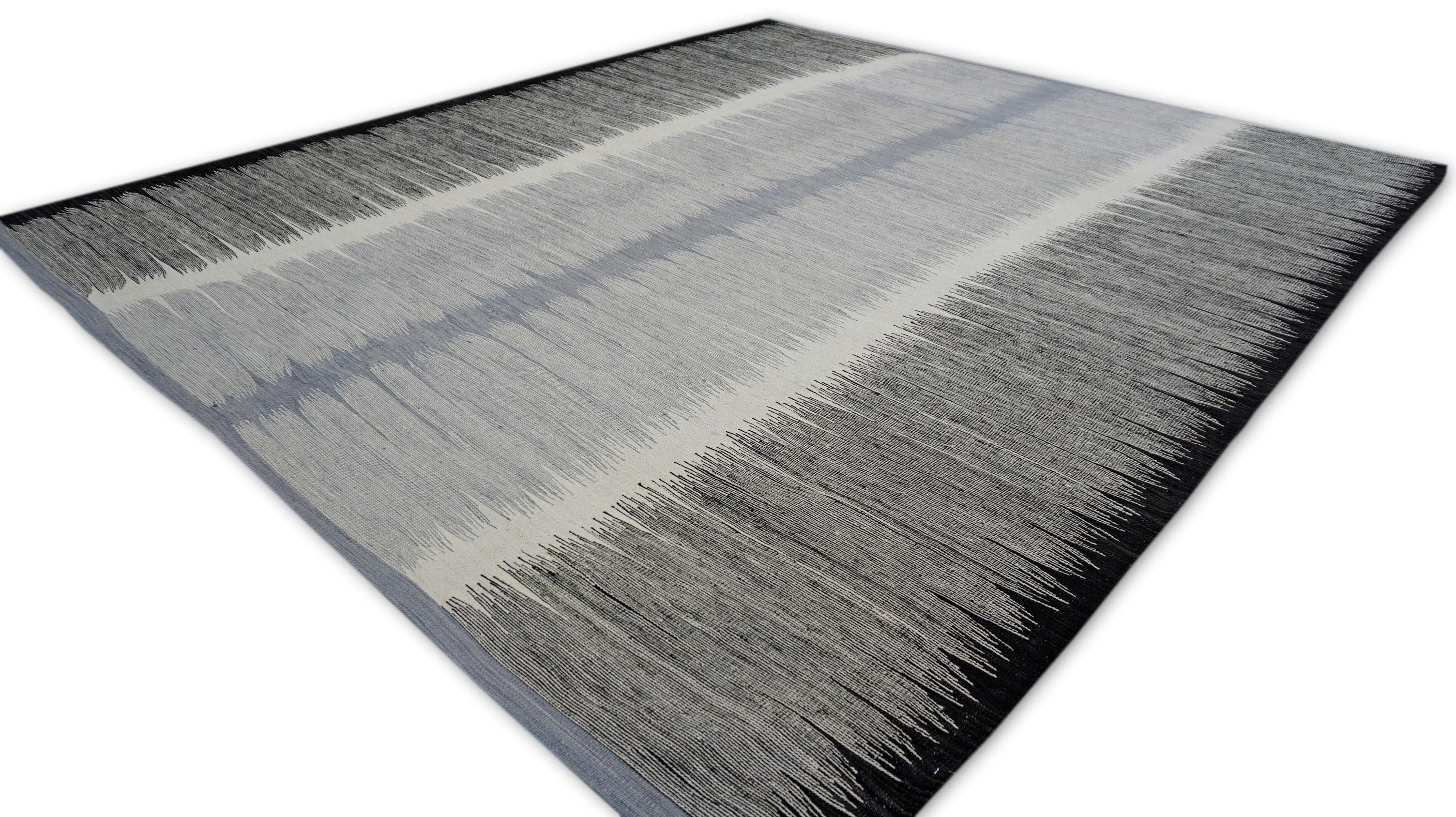 This striking handwoven modern kilim showcases a sophisticated blend of tradition and contemporary artistry. Crafted using hand-spun wool, this flatweave kilim embraces a minimalist aesthetic with a bold monochromatic gradient design, moving