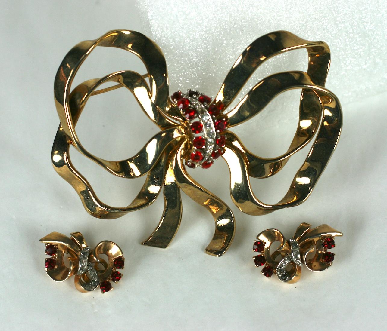 Mazer Retro massively scaled bow Retro knot brooch and matching ear clips. The multi loop bow and ear clips of 14 KT yellow gold plate with crystal rhinestone pave and faux round faceted rubies.  1940's USA. 
Excellent Condition, Signed Mazer.