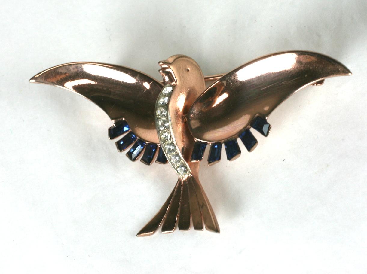 Mazer Retro rose gold plated sterling silver flying dove brooch. The outspread wings are trimmed with sapphire diagonal cut baguette feathers. A  line of crystal rhinestone pave defines the doves breast. Signed Mazer Sterling.
1940's USA.   