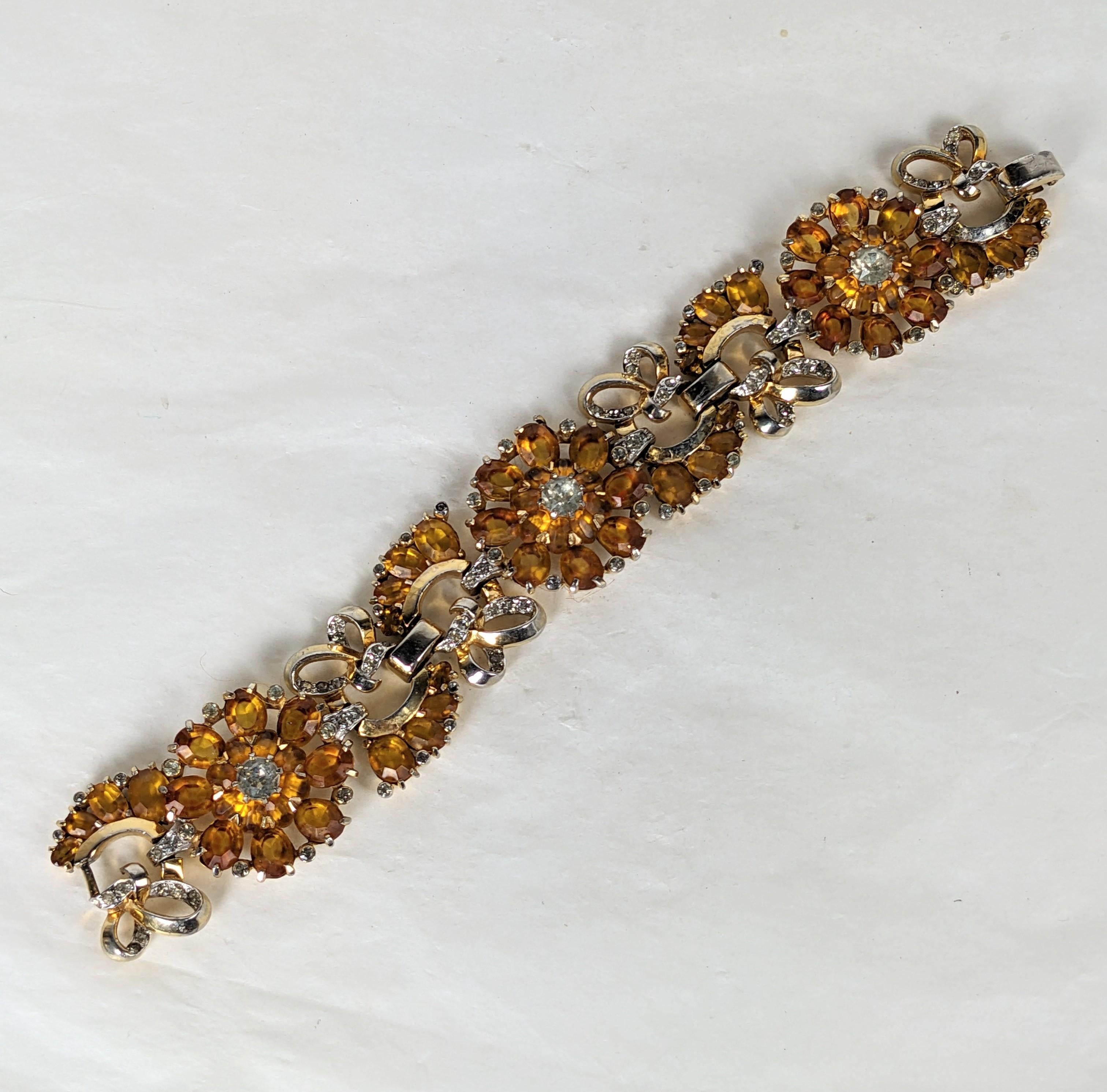 Mazer Topaz and Citrine Flower and Leaf link bracelet. Of rhodium plate and gold plate base metal with crystal rhinestone pave, and vari size topaz and citrine oval faceted stones. 1940's USA.
For similar examples of the flower and leaf motif see