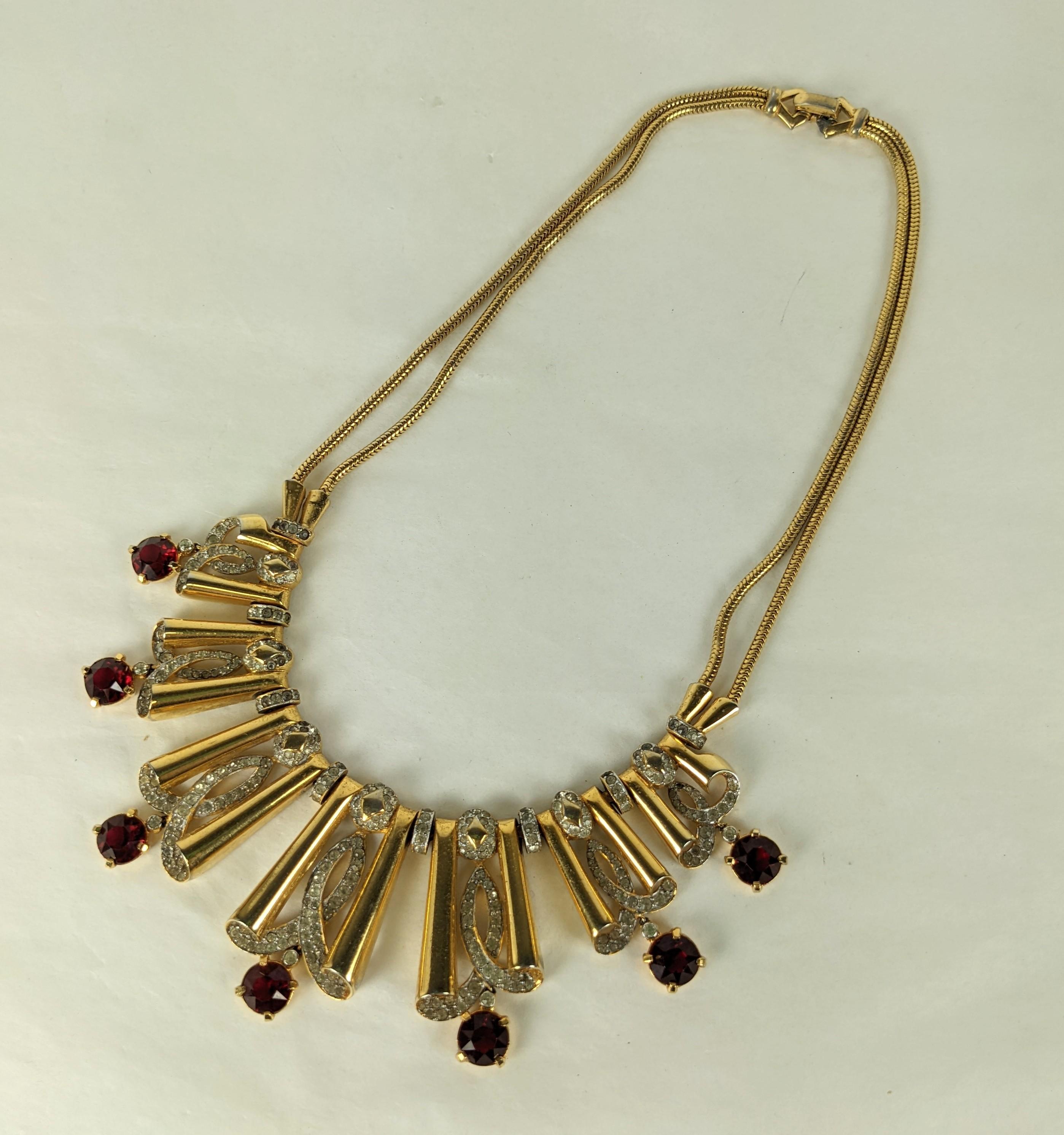 Important Mazer wide Retro link necklace of rhodium plate base metal and yellow gold plate. Composed of overlapping linked retro half bows with crystal pave rhinestone accents and large focal faux rubies and articulated drops. Woven double fox chain