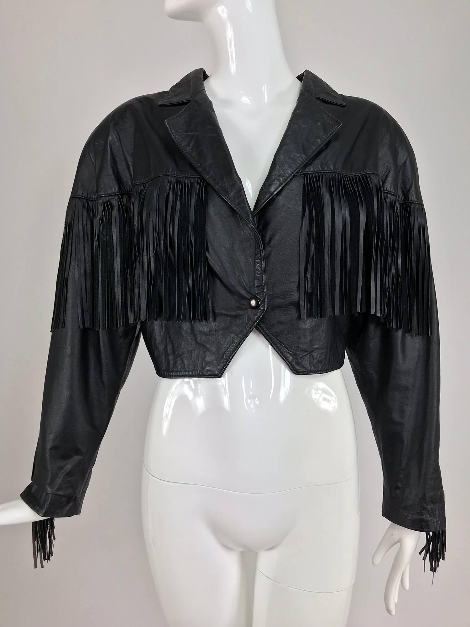 Maziar Betty Boop cowgirl black fringe leather jacket from the 1980s...Cropped jacket with a deep front yoke that is trimmed in long black leather fringe, the fringe continues around the arm and runs down the arm to the wrist...Notched lapels,