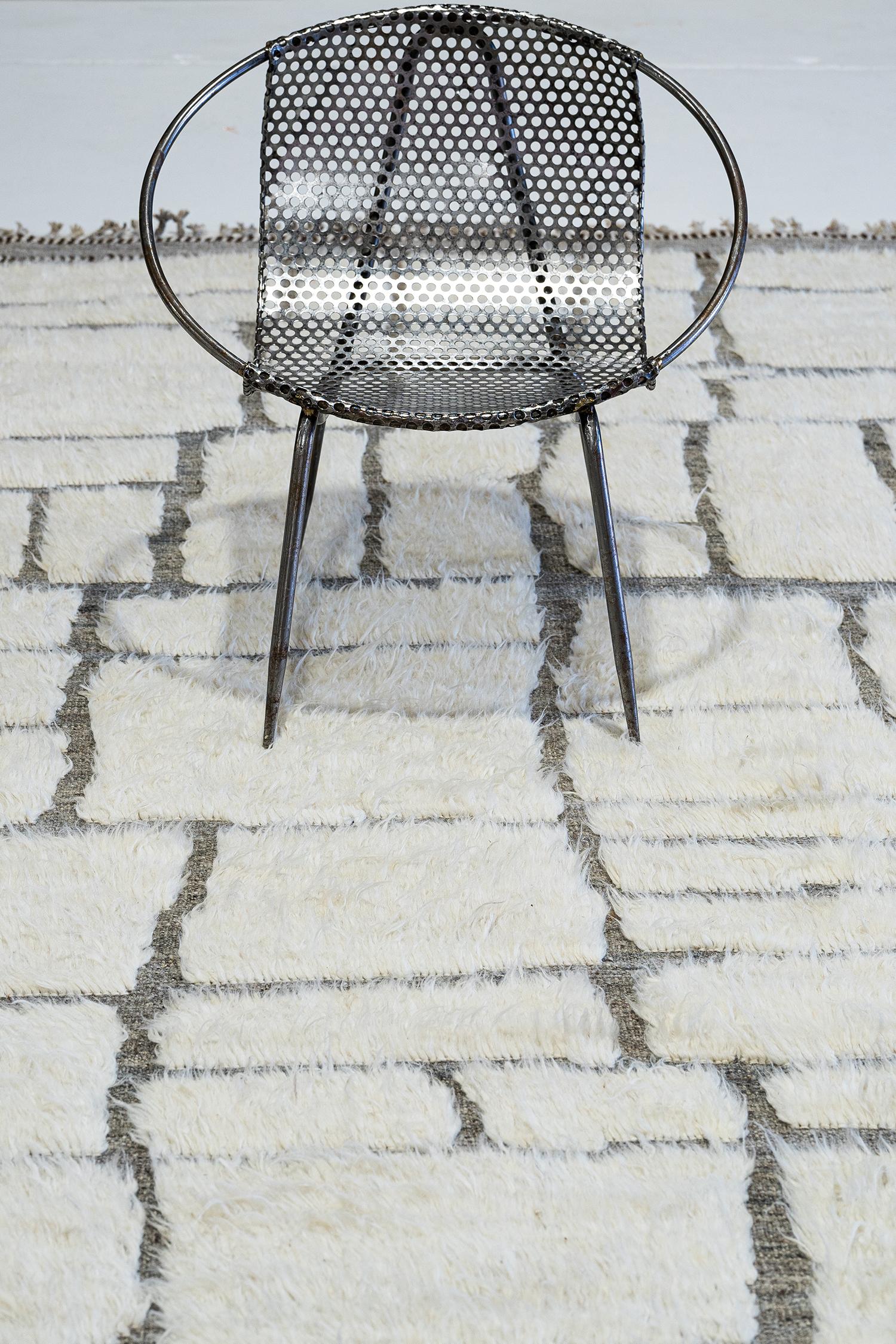 Maziere' is a handwoven wool piece with unique design elements that mirror roman masonry. This luxurious gray pile weave and white shag make for the perfect contemporary. Maziere is designed in Los Angeles for the modern design world.
