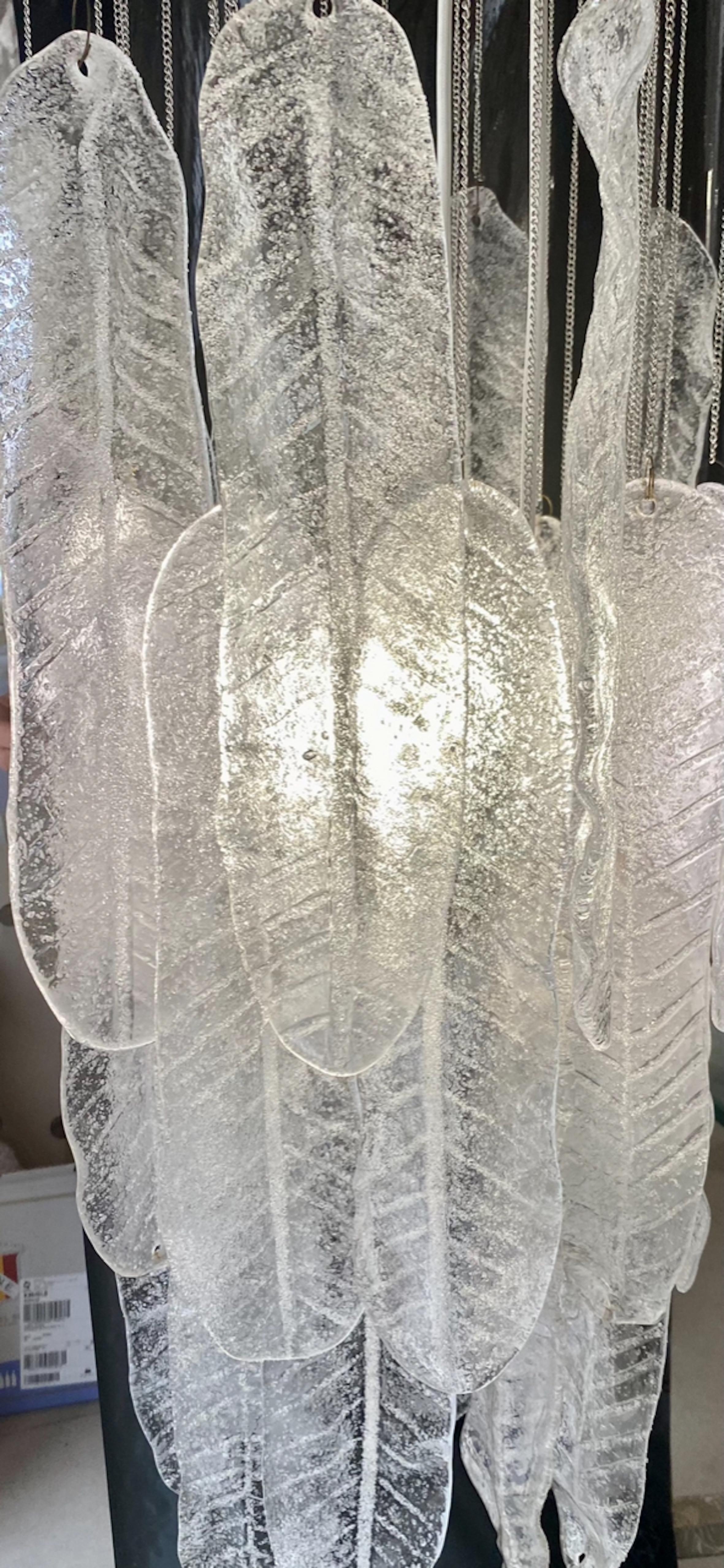 Exceptionnel pendentif en cascade avec feuilles en verre Murano surdimensionné d'environ 30 cm avec structure en CHROME. Le design et la qualité du verre font de cette pièce le meilleur du design italien.
Ce pendentif unique en cascade Mazzega en