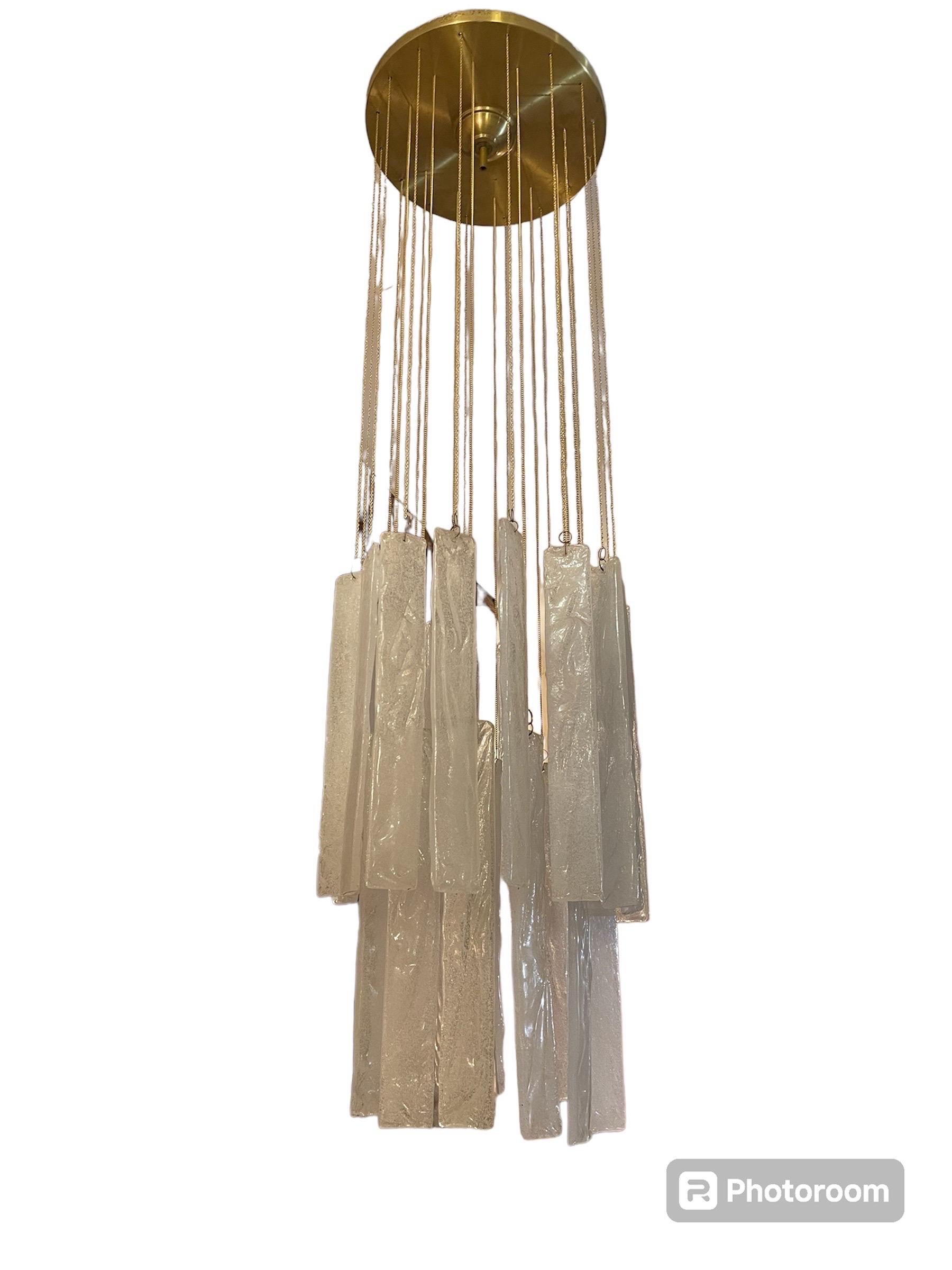 Exceptional cascade pendant with leaves ice frost glass Murano oversized around 30 cm with brass structure. The Design and the quality of the glass make this piece the best of the italian Design.
This unique Mazzega cascade pendant in bicolore glass