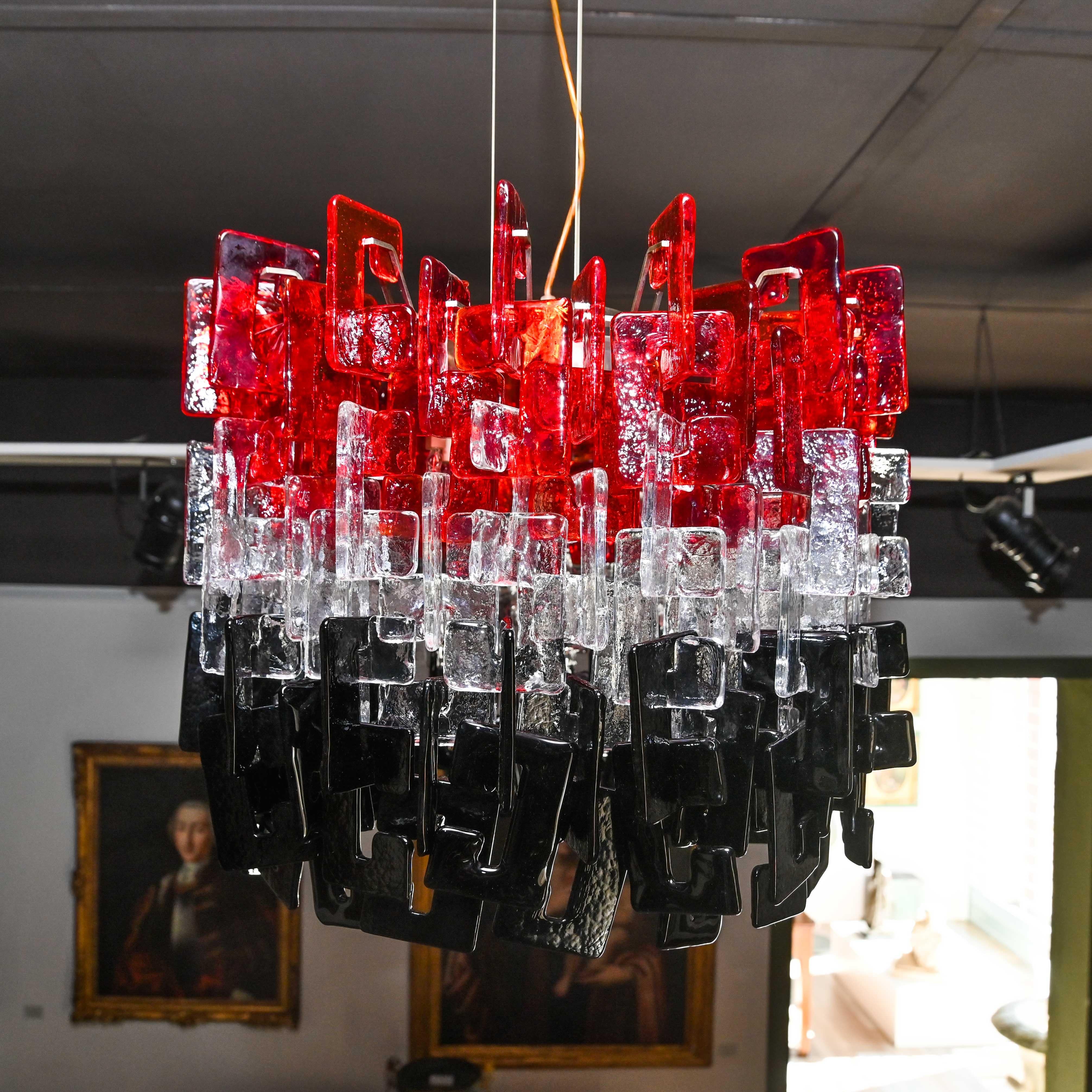 AV Mazzega Sixty collection chandelier. Composed of 192 total glasses (64 per color: red, transparent and black), hand-worked plate glass, assembled by interlocking, on a chromed metal structure.