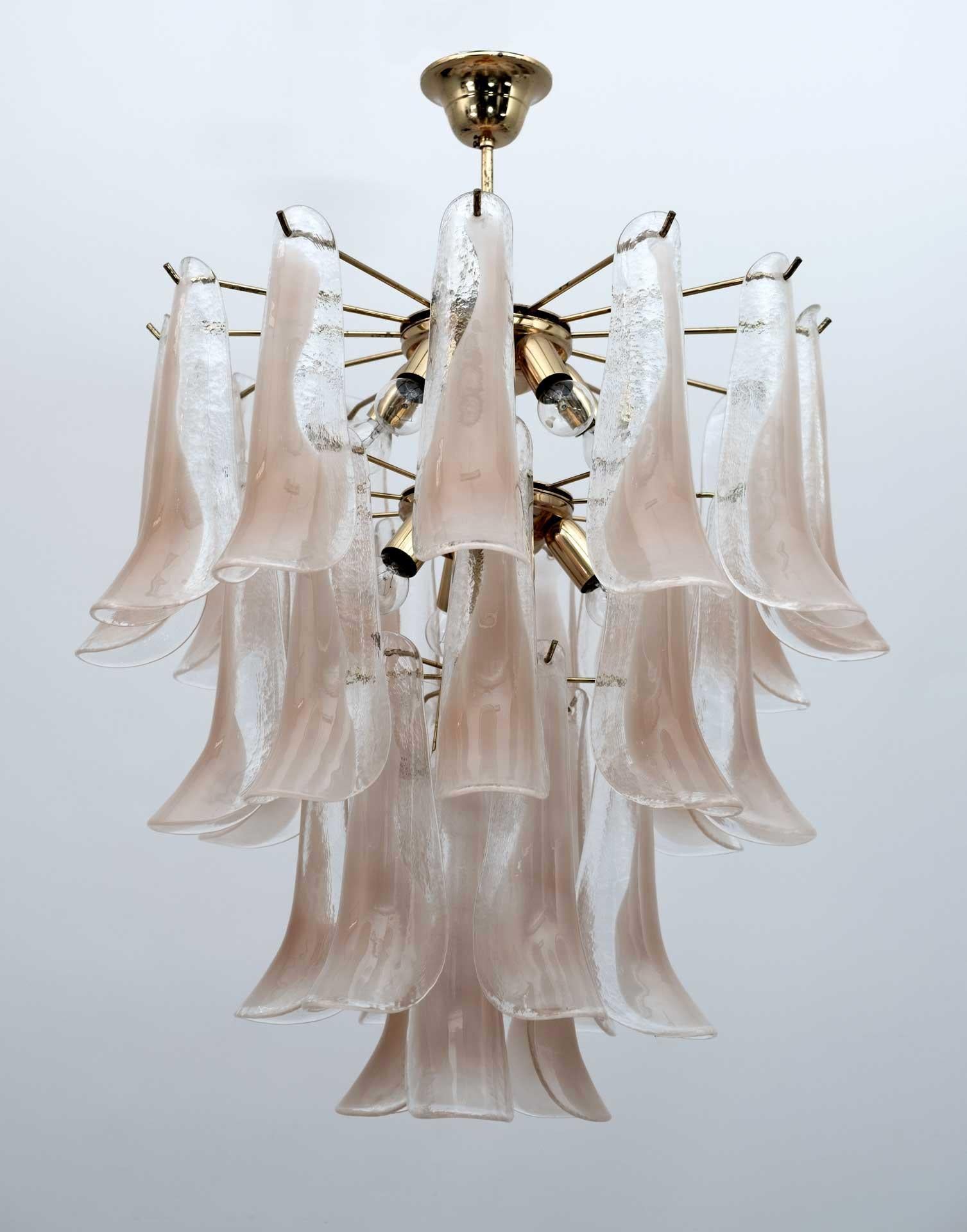 Murano chandelier produced by Mazzega, composed of 30 pink and transparent glass petals supported by a golden brass structure.
The clear, light pink color of the glasses creates a fabulous warm light effect.
Period: 70s
Dimensions: 85cm high with