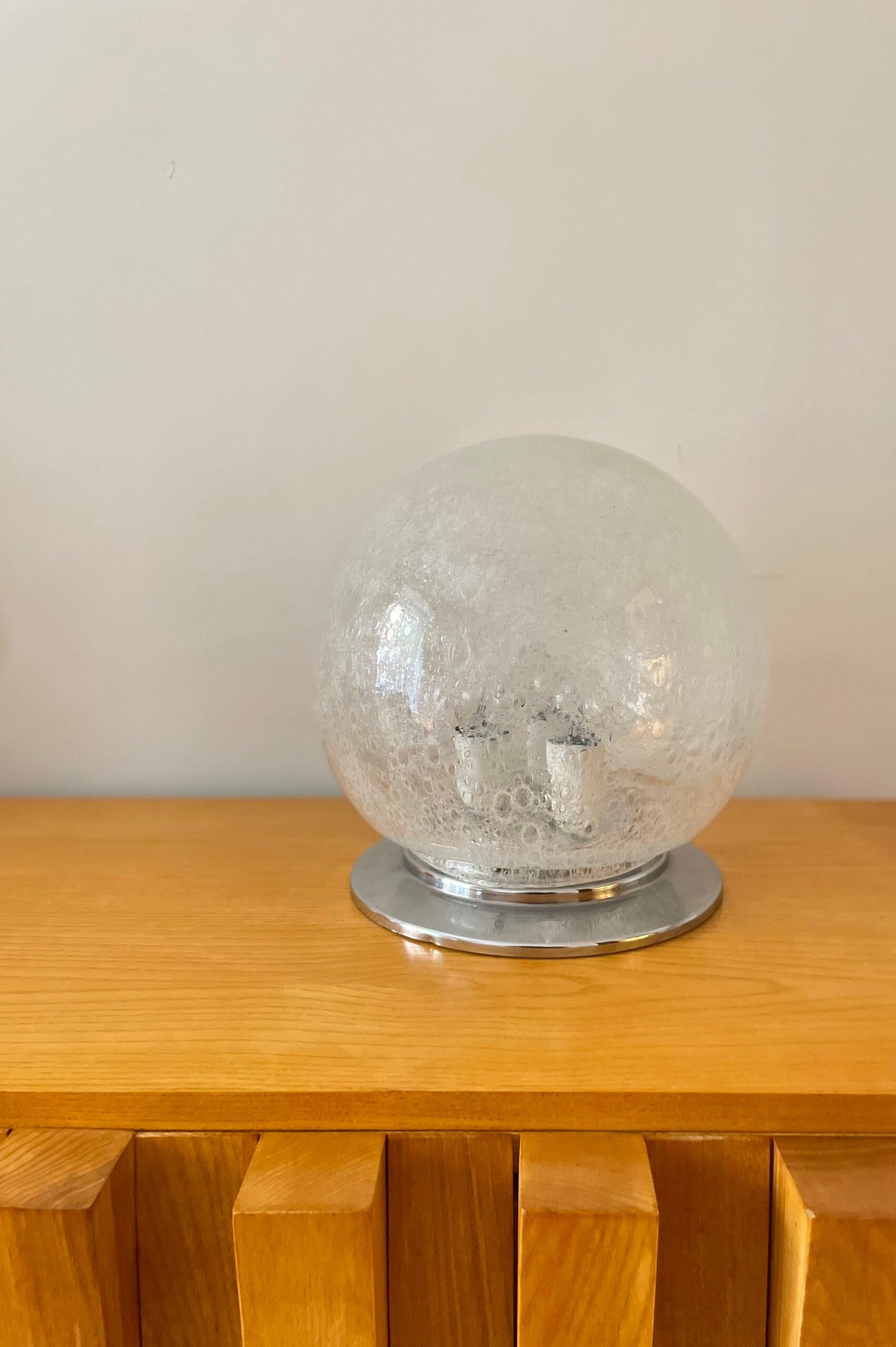 Lustre Murano fabriqué par Mazzega avec la technique Bullicante et base chromée. Italie, années 1950.

Hauteur : 30cm
Diamètre : 29 cm
*3 ampoules

L'usine A.V. Mazzega a été fondée en 1946 à Murano, le berceau du verre d'art vénitien. Dès ses