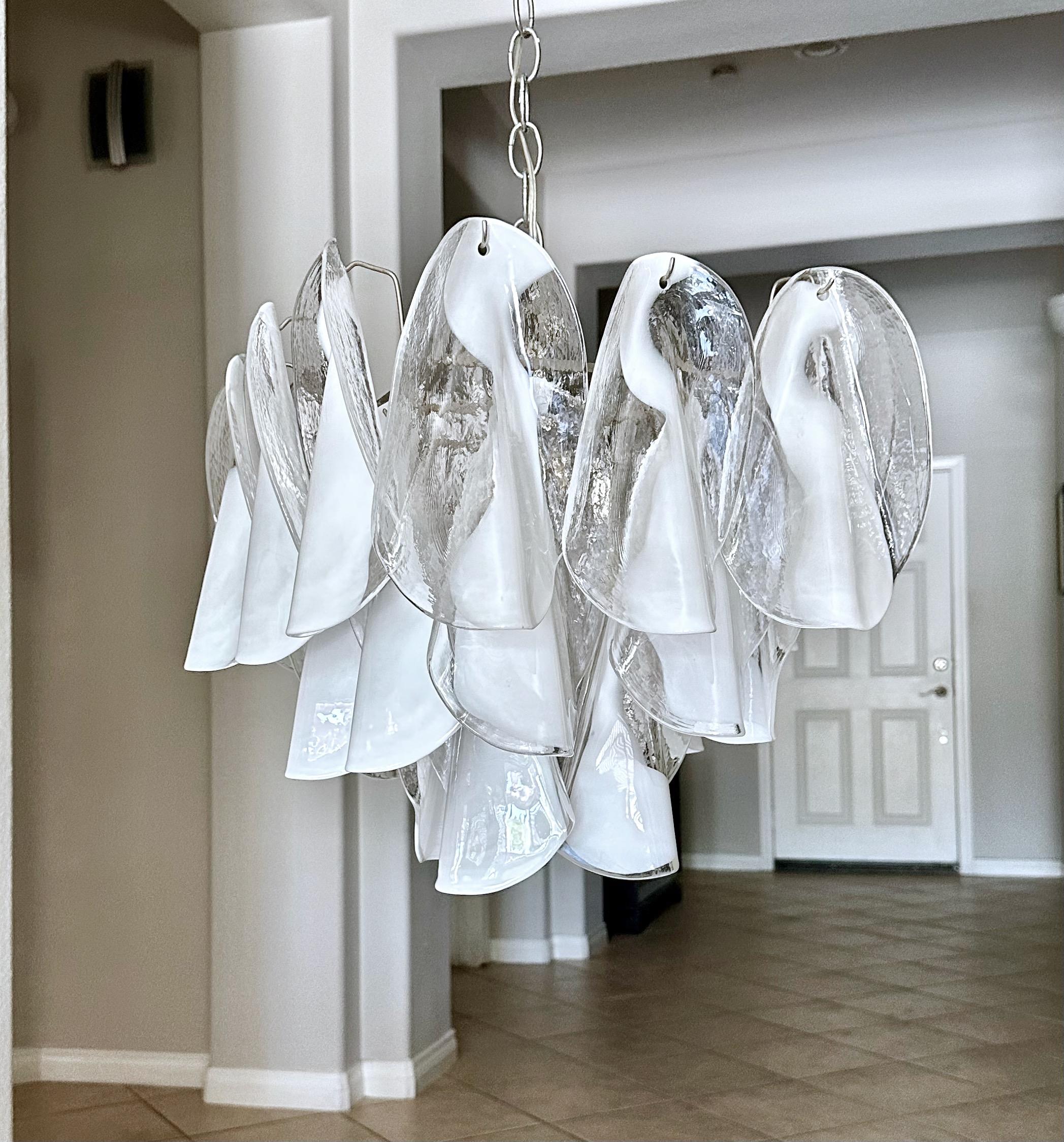 Araña de pétalos blancos y transparentes soplada a mano Mazzega. Pétalos de cristal suspendidos en un armazón de acero de cuatro luces recién cableado. Medidas: forma cuadrada 15