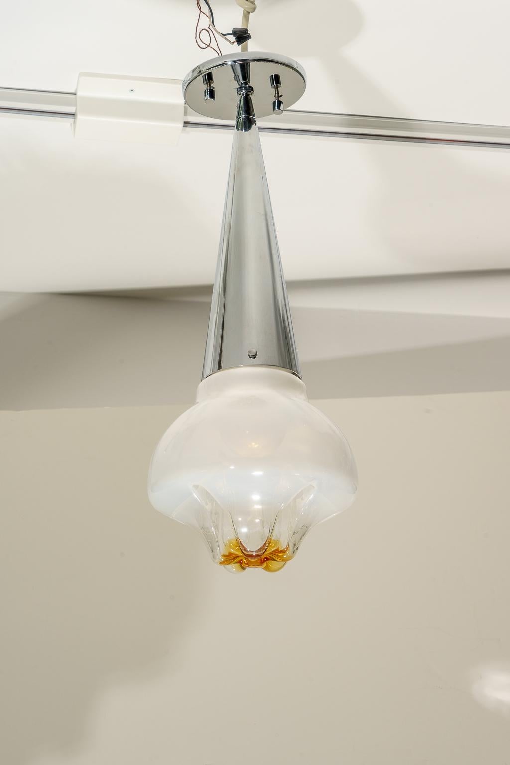 This stylish Mid-Century Modern chandelier dates to the 1960s-1970s and was created by the iconic Italian Murano glass artisans of Mazzegan.

The molten globe is in colorations of white, clear and translucent amber.

Note: Requires on Edison