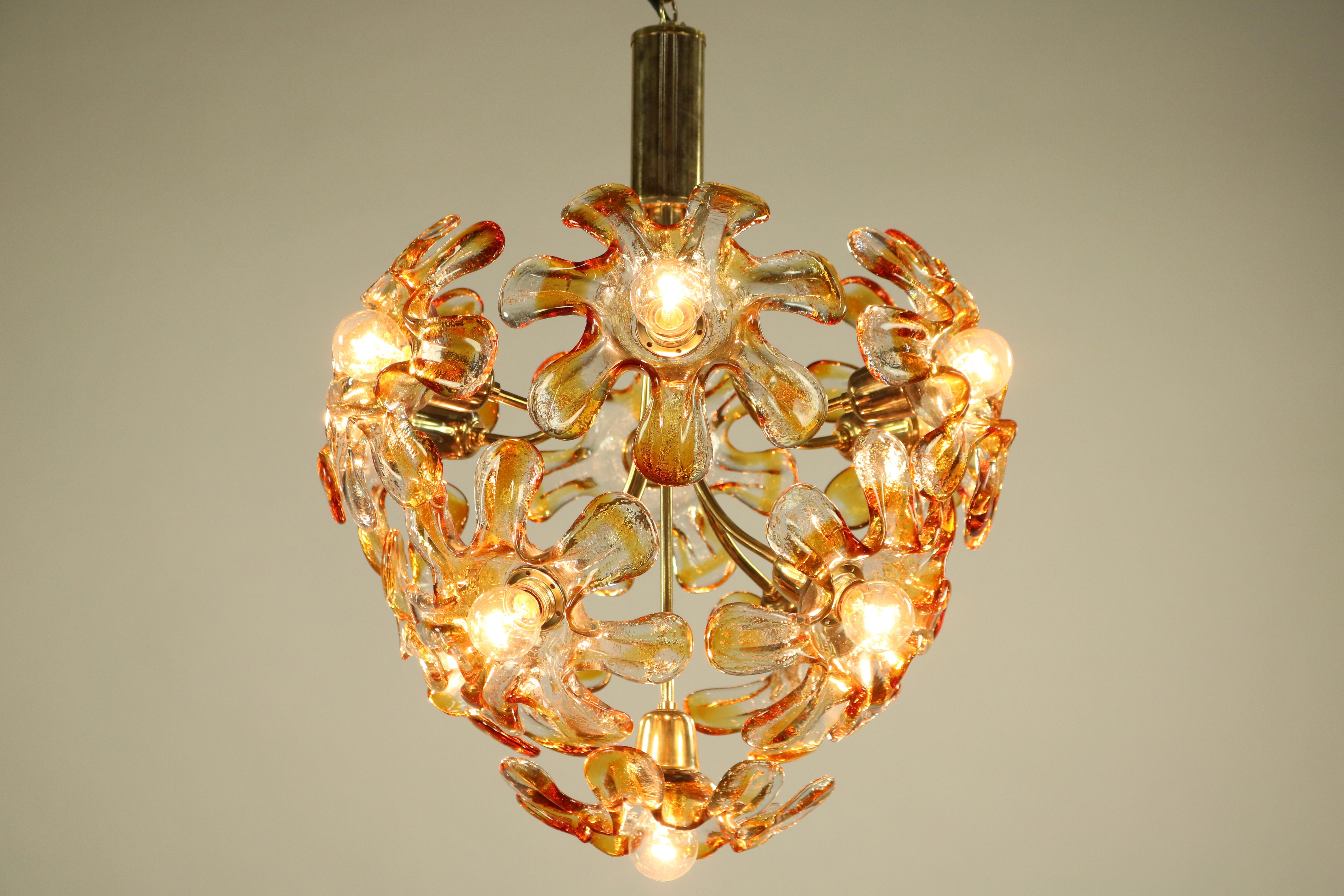 1960s pendant light - Murano glass chandelier
Made of a gilded steel frame with 11 clear and amber colored glass blossoms
This is the large version there were also smaller ones available
In very fine condition only one glass part with a small cut