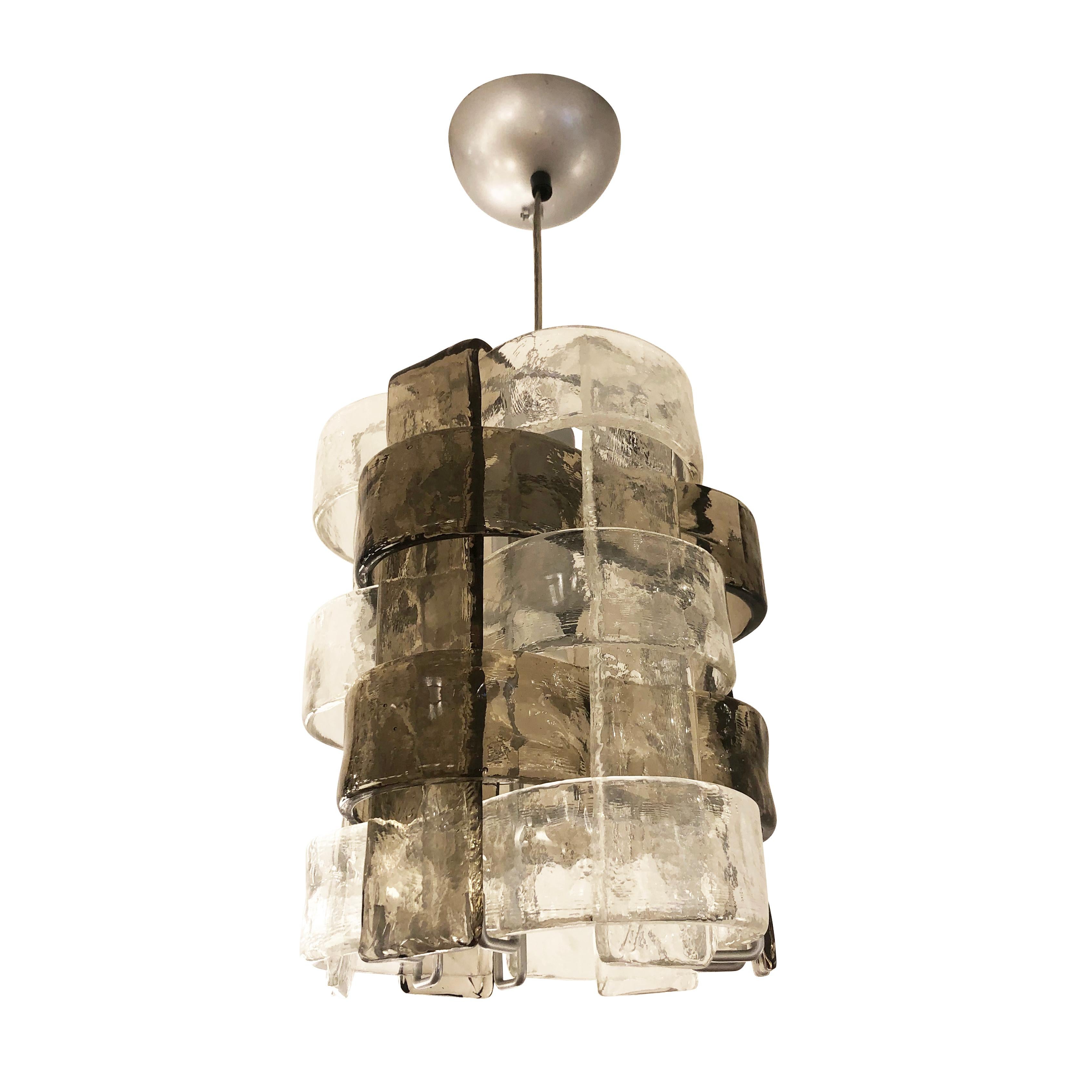 Murano glass pendant by Mazzega composed of interlacing clear and gray textured glasses. Height can be easily adjusted using the steel cable. Holds one E26 bulb.

Condition: Excellent vintage condition, minor wear consistent with age and