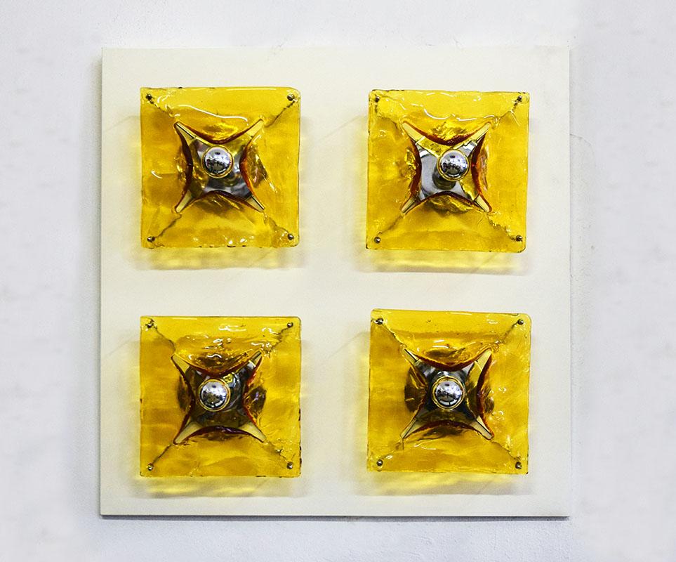 Aplique grande Mazzega Murano de los años 70.
Aplique de pared de 4 luces sobre panel de madera lacada en blanco.
Soportes cromados con vidrio soplado grueso en amarillo/naranja.
En excelente estado.