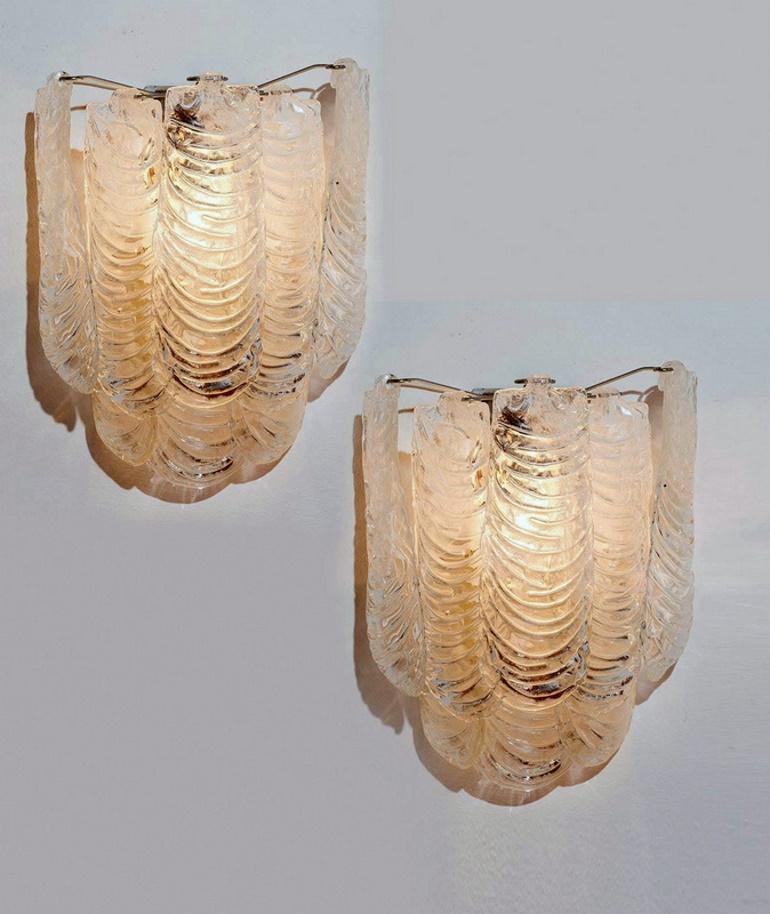 Extraordinary pair of wall lamps in Murano glass; they have been realized by the firm Mazzega in Murano (Italy) between 1960 and 1965; in the strong structure in heavy metal of each wall lamp is housed the electrical system with three points of