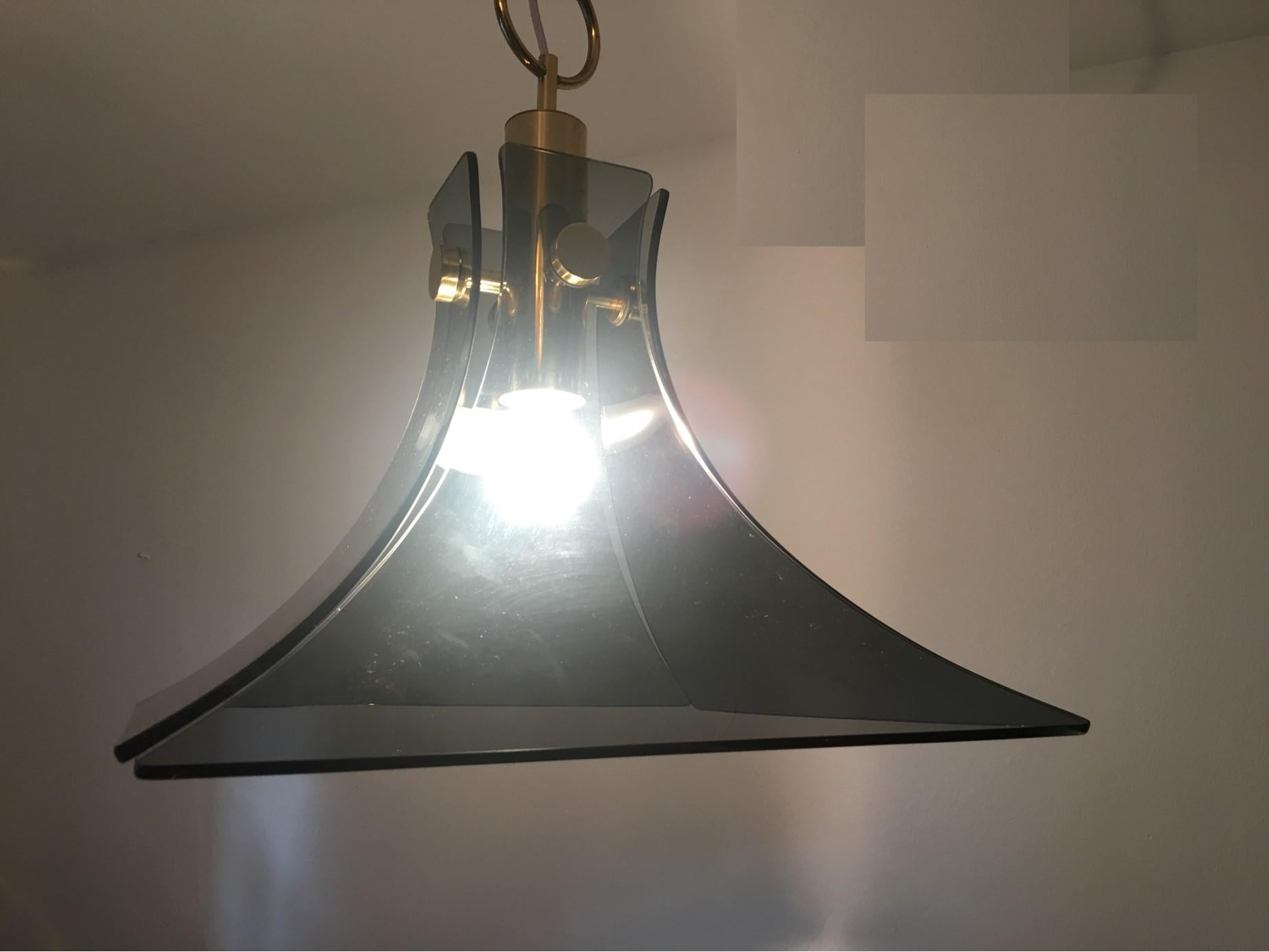 A lovely chandelier with four smoked glass plates surrounded by timeless Brass fixtures. In the style of Carlo Nason for Mazzega. This fixture requires one European E27 Edison Bulb with a maximum of 60 Watts. It is rewired to meet US