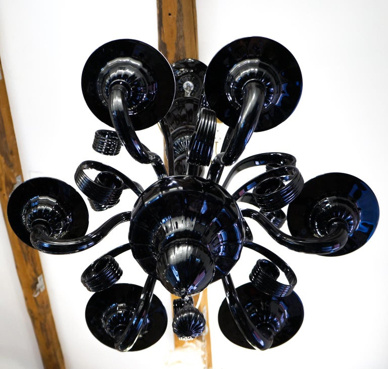 Here is a great classic from 1984 designed by Daniele Mazzucato. This chandelier is composed of 22 glass elements, among which six are arms. Each one, bring a light bulbs that creates fashinating lights reflections with the black color of the