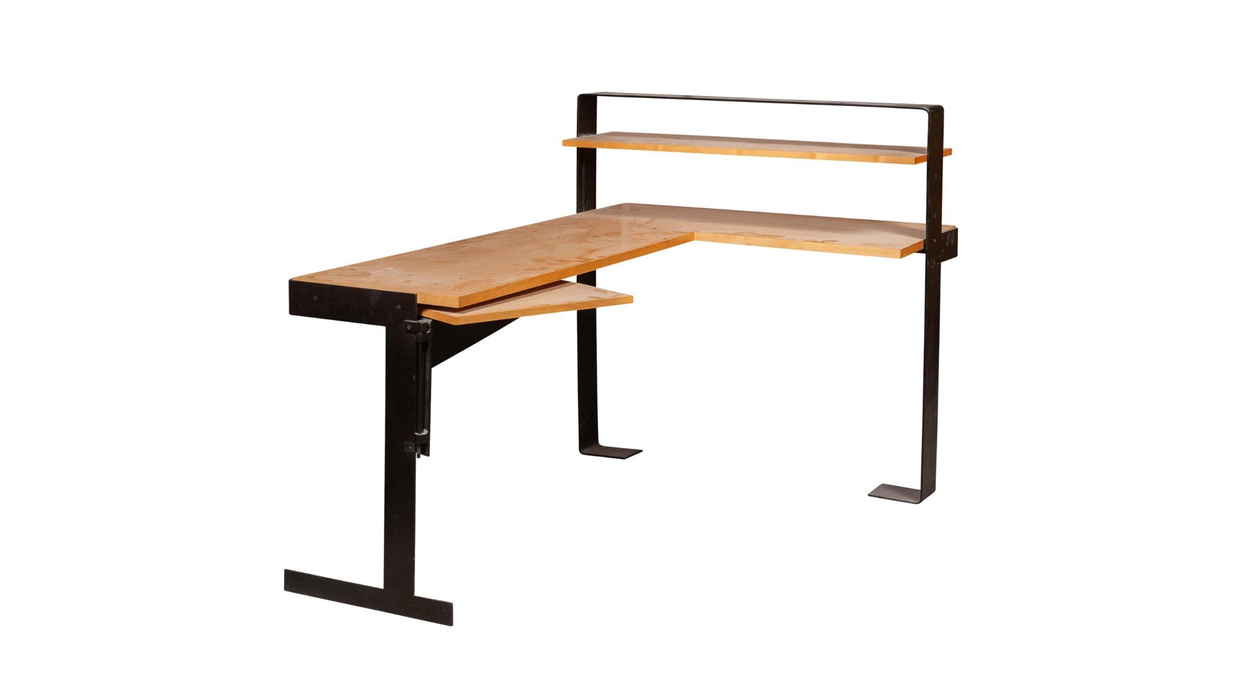 D'après Pierre Chareau
Corner desk in wood and wrought iron with black patina.
Measures: 41.4 x 62.9 x 41.5 in.
Bureau d'angle.
En bois blond, à gradin latéral droit formé de trois tablettes, dont l'une mobile à gauche, sur une structure en fer
