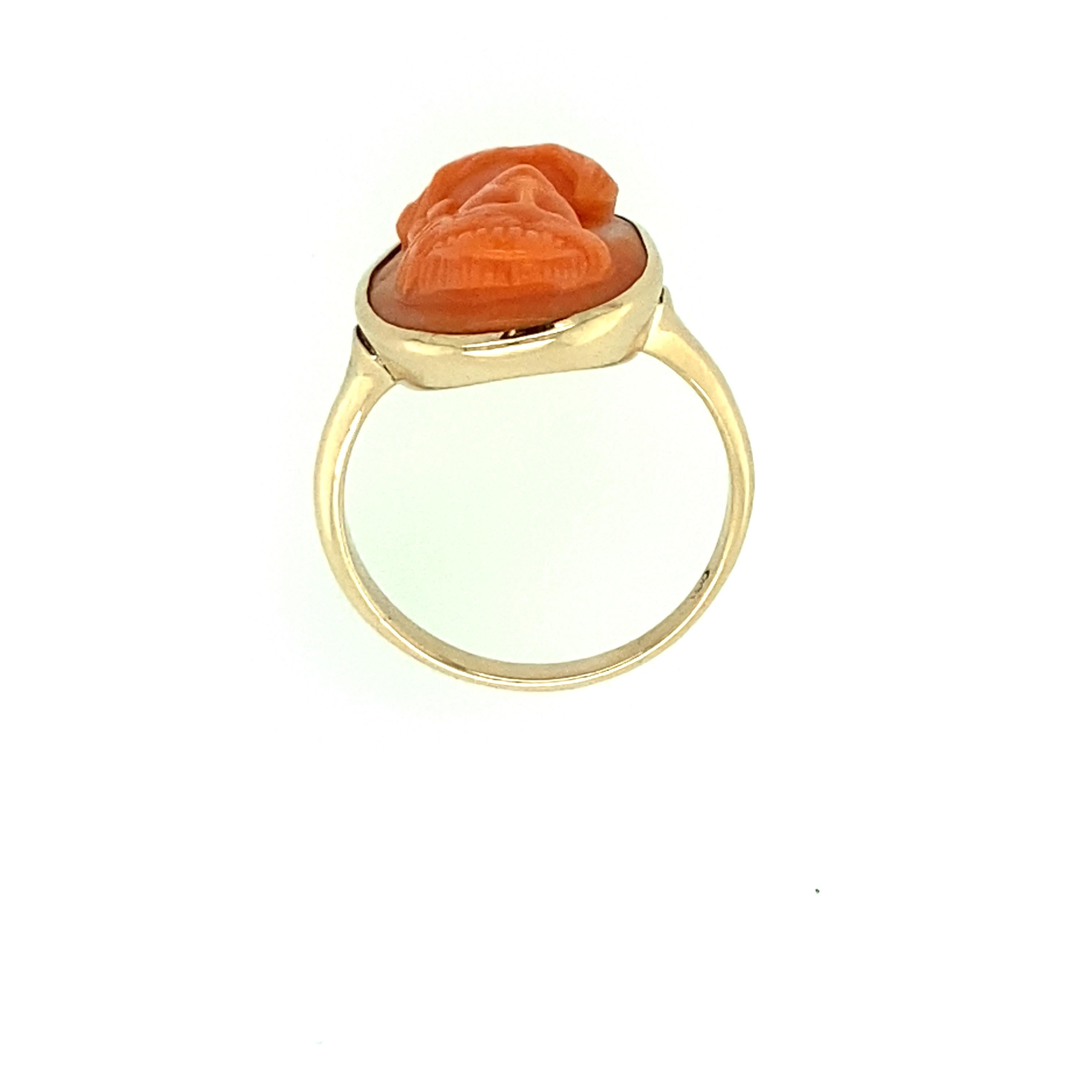 One 10 karat yellow gold (stamped with triple ring hallmark) orange cameo ring measuring 17.27x13.23mm.  The shank measures 3.06mm near the top of the ring and tapers to 2.11mm at the base.  Finger size 6.25. Circa 1920s 
