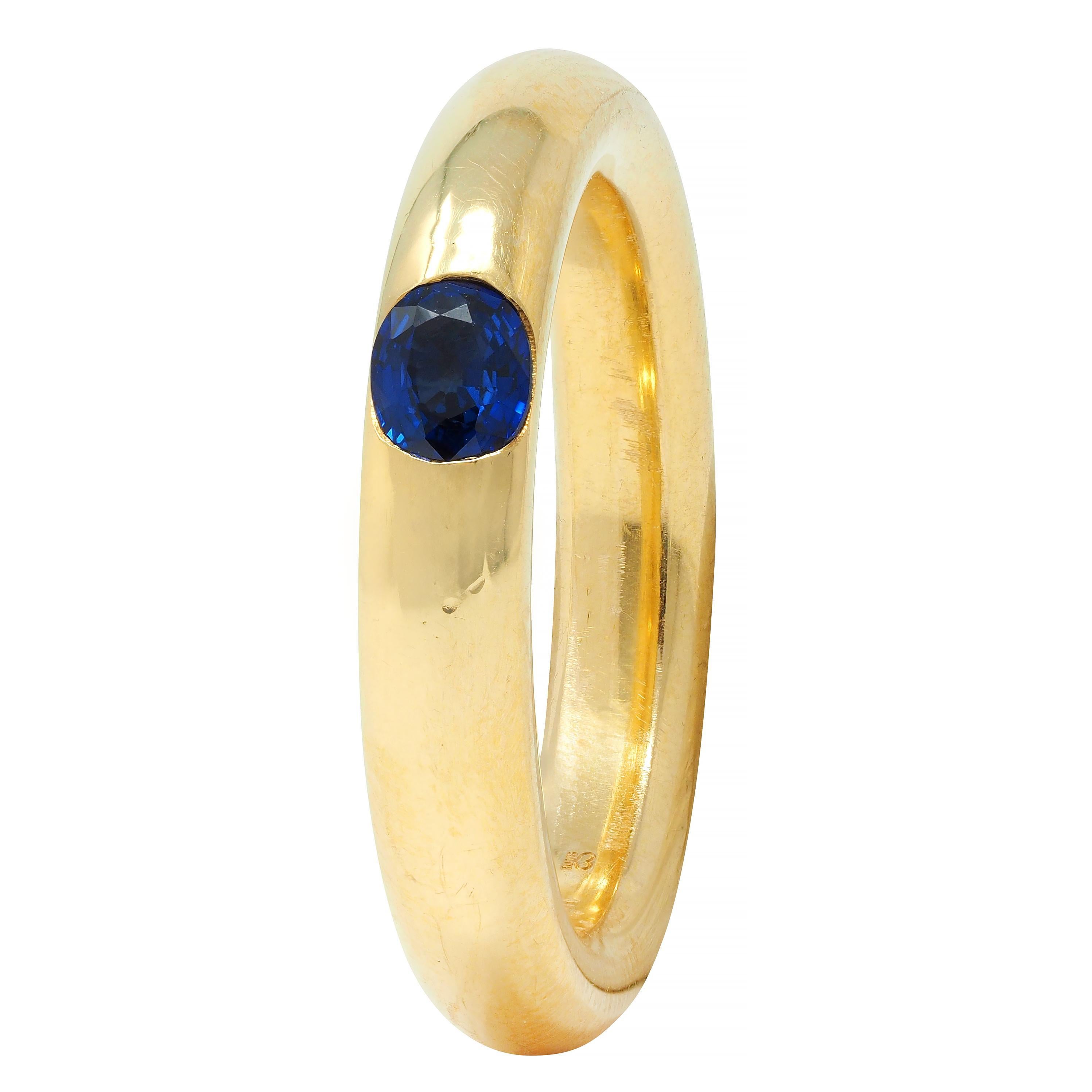 Centering a cushion cut sapphire weighing approximately 0.50 carat 
Transparent medium blue in color and flush set east to west
With a rounded gold donut-style shank
Complete by high polish finish
Inscribed 'SA OE' under a heart
Stamped for 18 karat