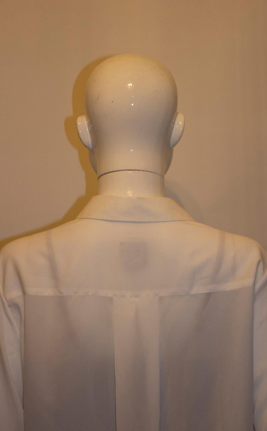 A great , classic white cotton mix ahirt by Mc Queen.  The shirt  has a double button cuff, and pattern on the breast pocket. Size 44  Measurements: Bust up to 42'', length 26''