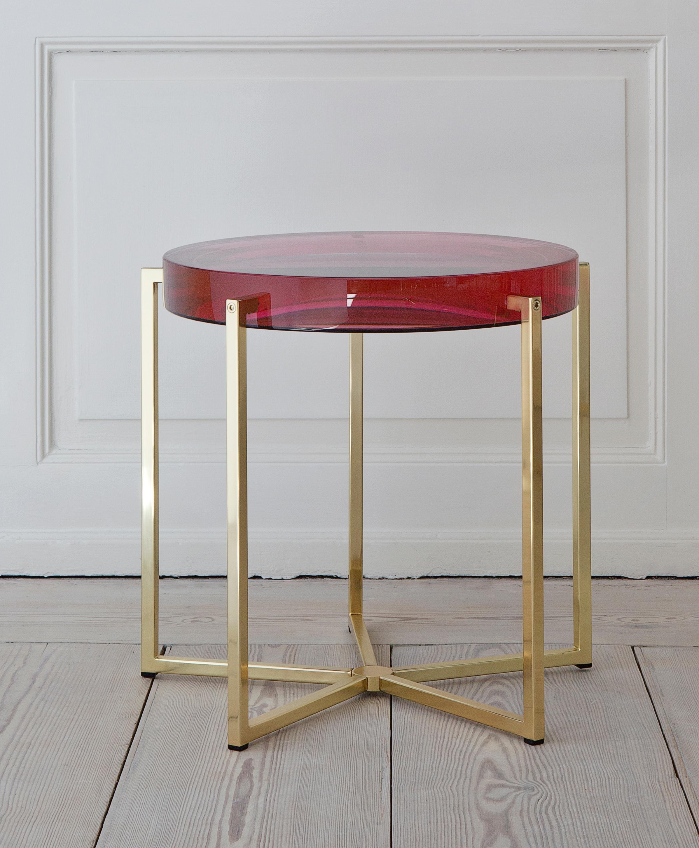 Lovely McCollin Bryan table with rose tinted resin top backed by acrylic mirror on brass base. 

A pre-occupation with materials as much as with shape and function, has led Don McCollin and Maureen Bryan to use resins and plasters in a