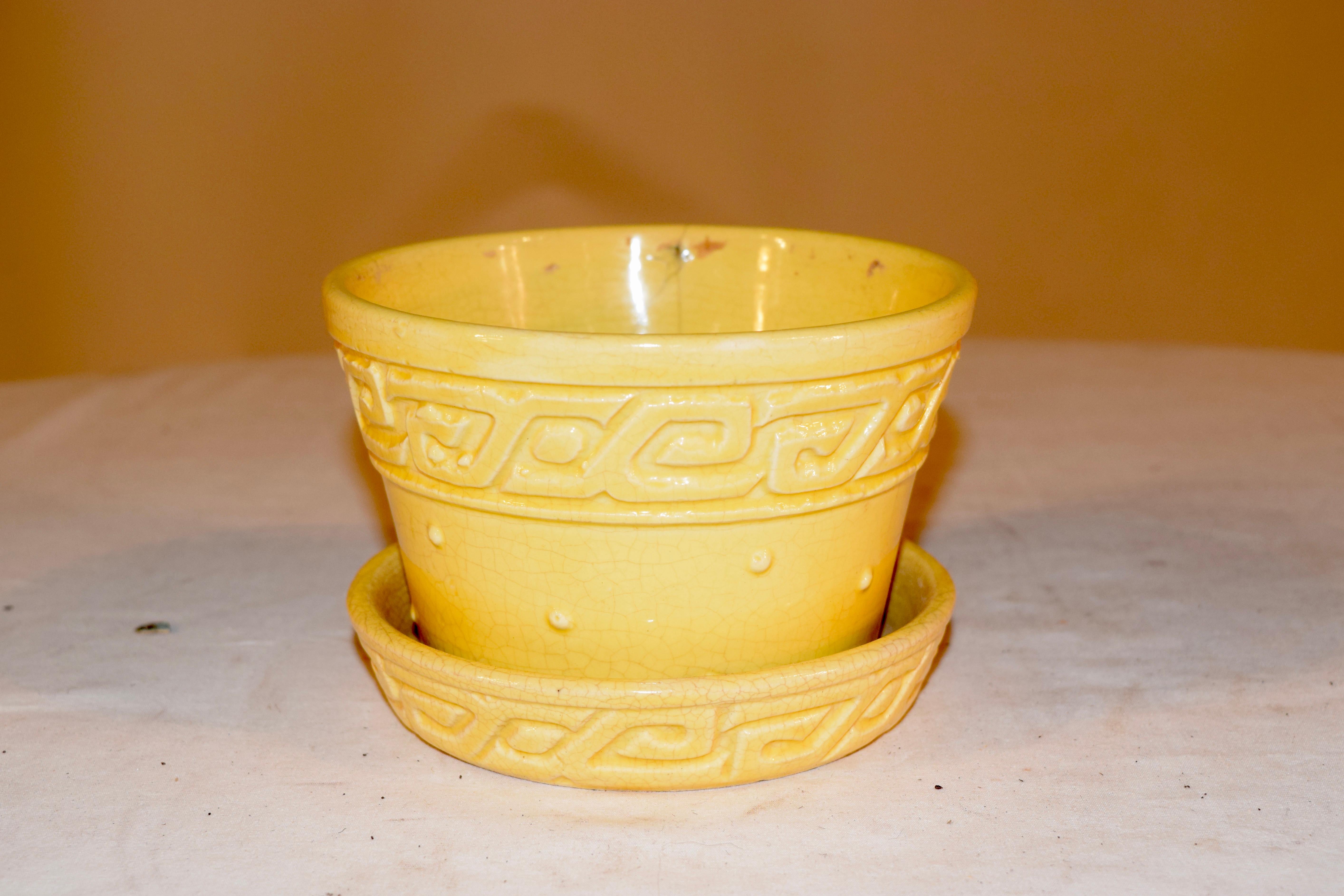 An original vintage 1950s McCoy ceramic planter. This midcentury piece is from the 1950s. A charming ceramic pot with Greek key design around the top rim and also on the attached saucer with yellow hues.