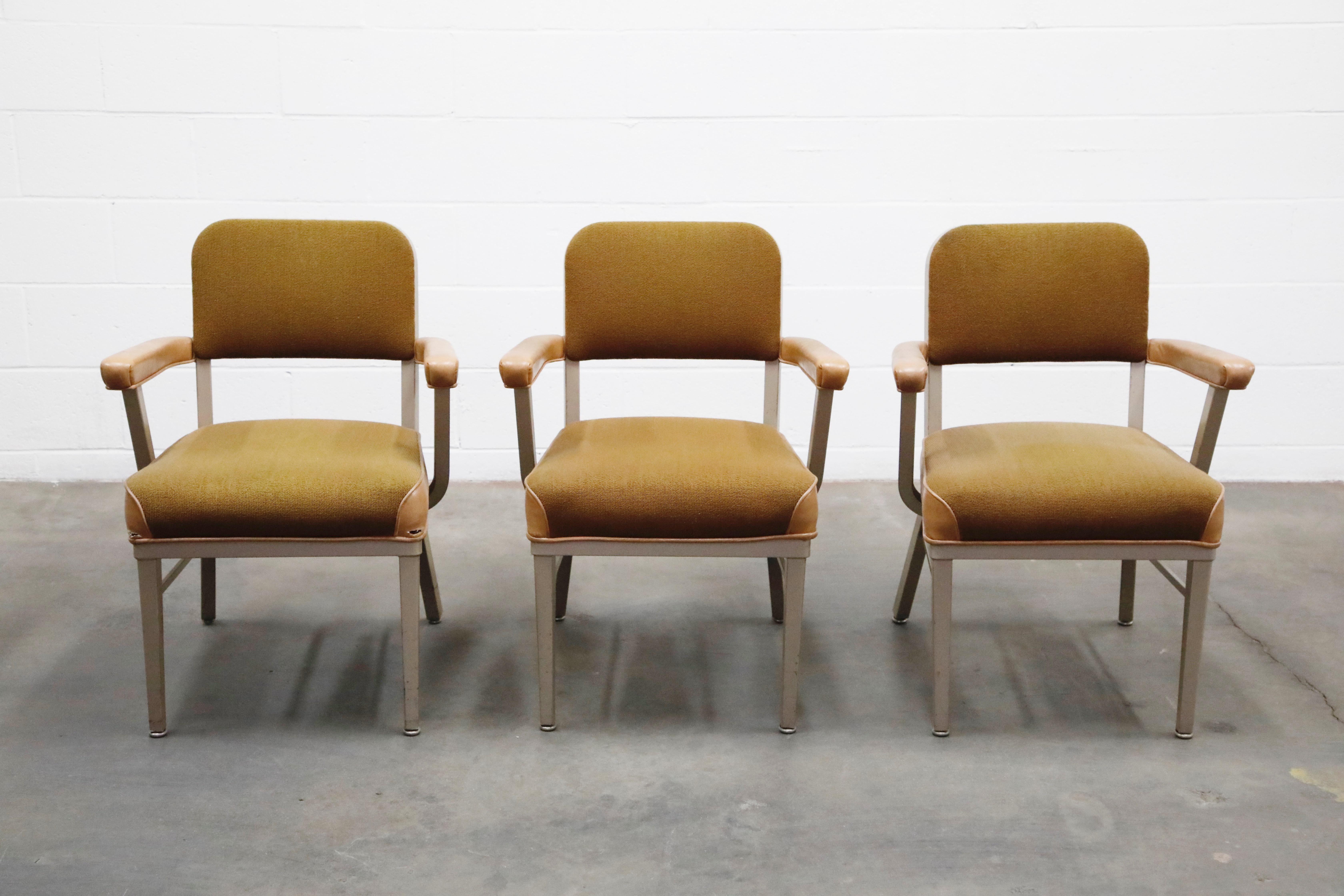A classic industrial office armchairs by McDowell-Craig, circa 1960, signed underneath with labels. Chairs are priced individually, three are available. Constructed with steel frames and upholstered arm pads, leatherette and fabric upholstery.