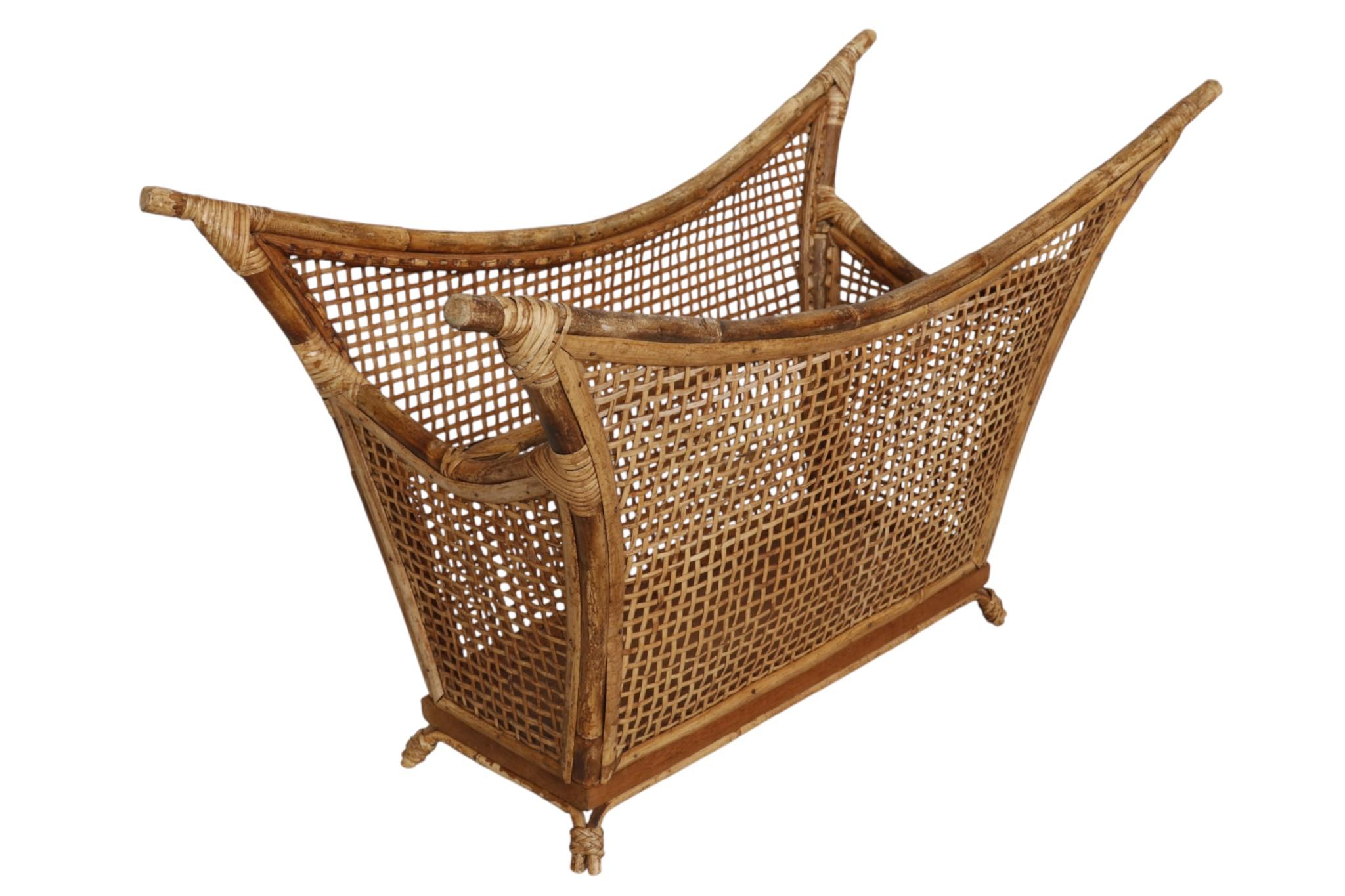 Un elegante revistero de bambú y ratán fabricado por John and Elinor McGuire, de San Francisco, fundadores de la empresa de muebles McGuire. El marco curvado de bambú soporta una celosía de ratán asegurada con ribetes de bambú partido y envoltura de