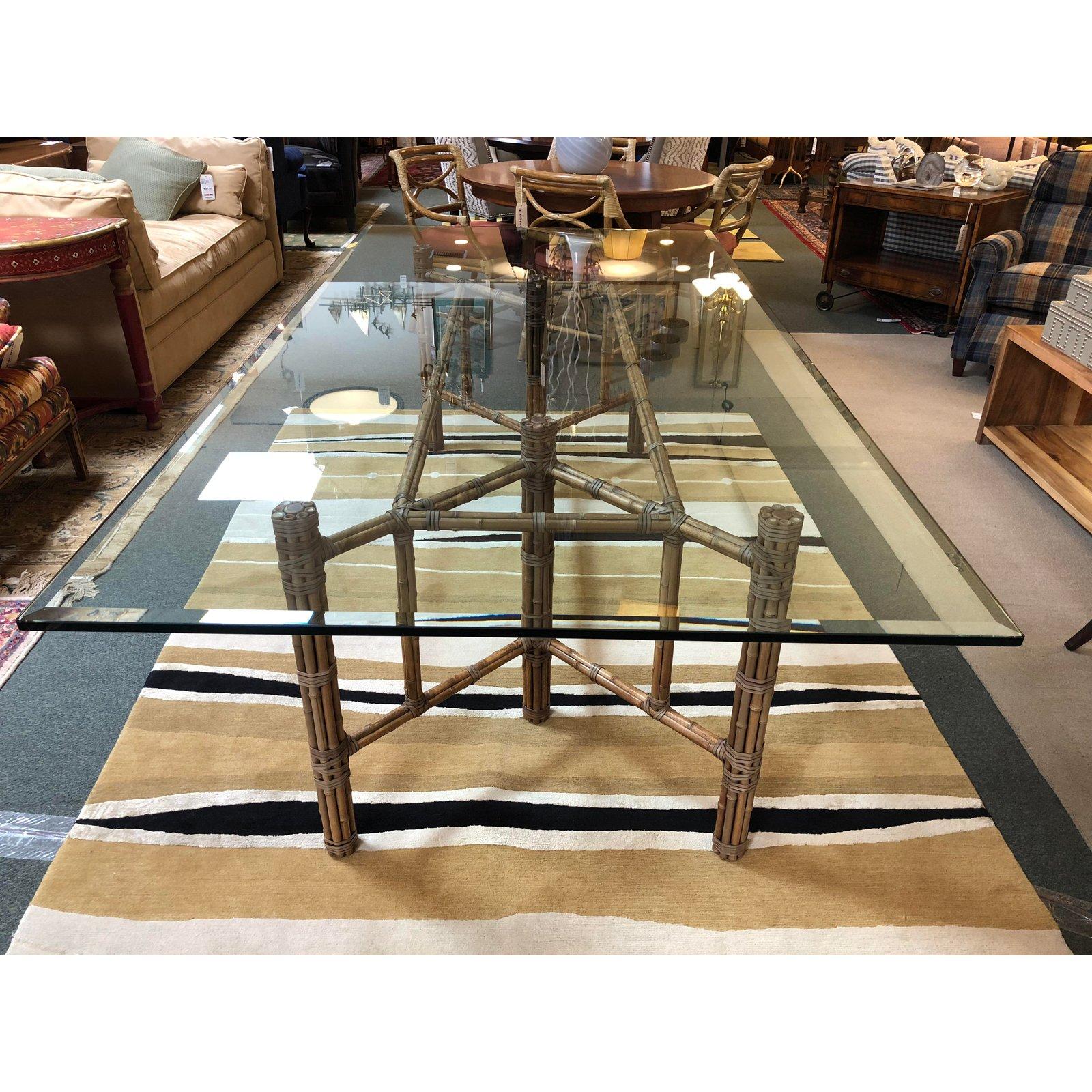 A McGuire dining table. The table base is made of bamboo rods wrapped around Iron rods, they are held in place with the quintessential McGuire Leather straps. The base is topped with a beveled glass. No leaves, glass 0.75 inch.
 