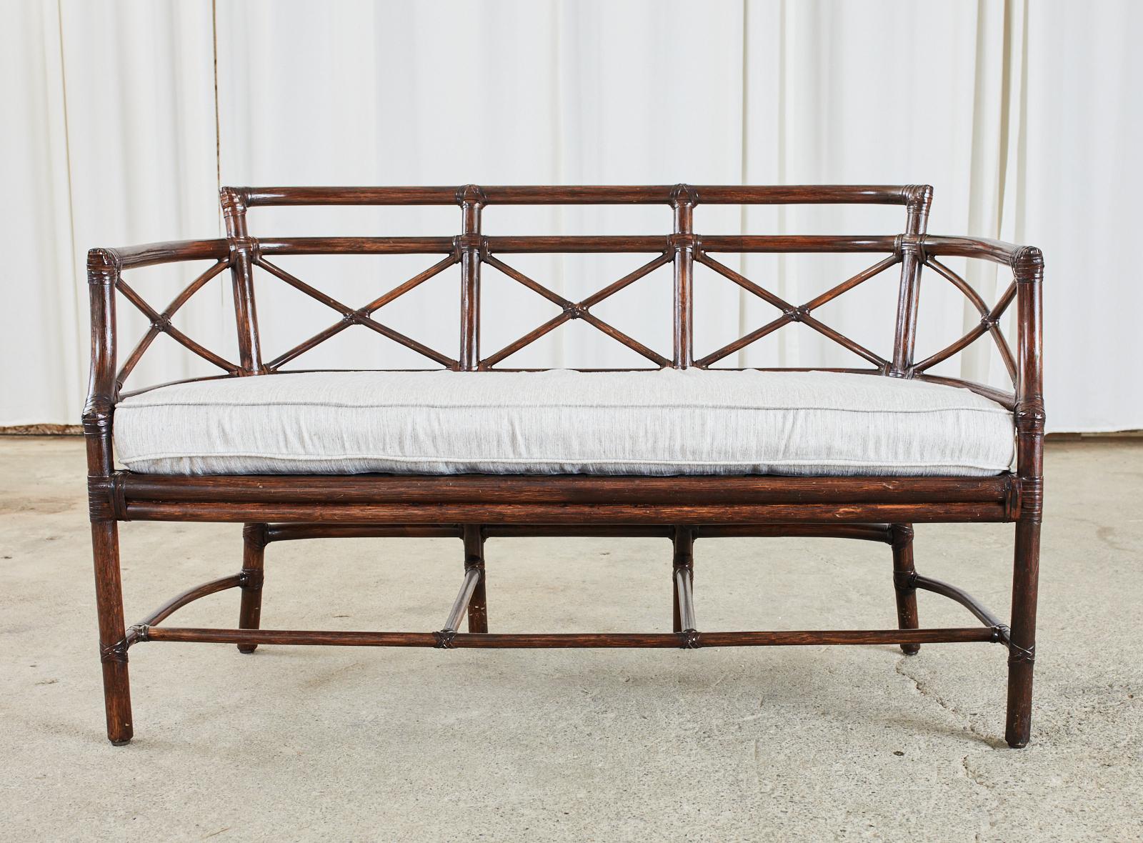 Genuine McGuire organic modern Gondola settee or bench crafted from bamboo rattan poles by McGuire. Designed by Elinor McGuire and inspired by Venetian gondolas in Italy. The frame has gracefully curved ends with X motifs in the back. The exposed