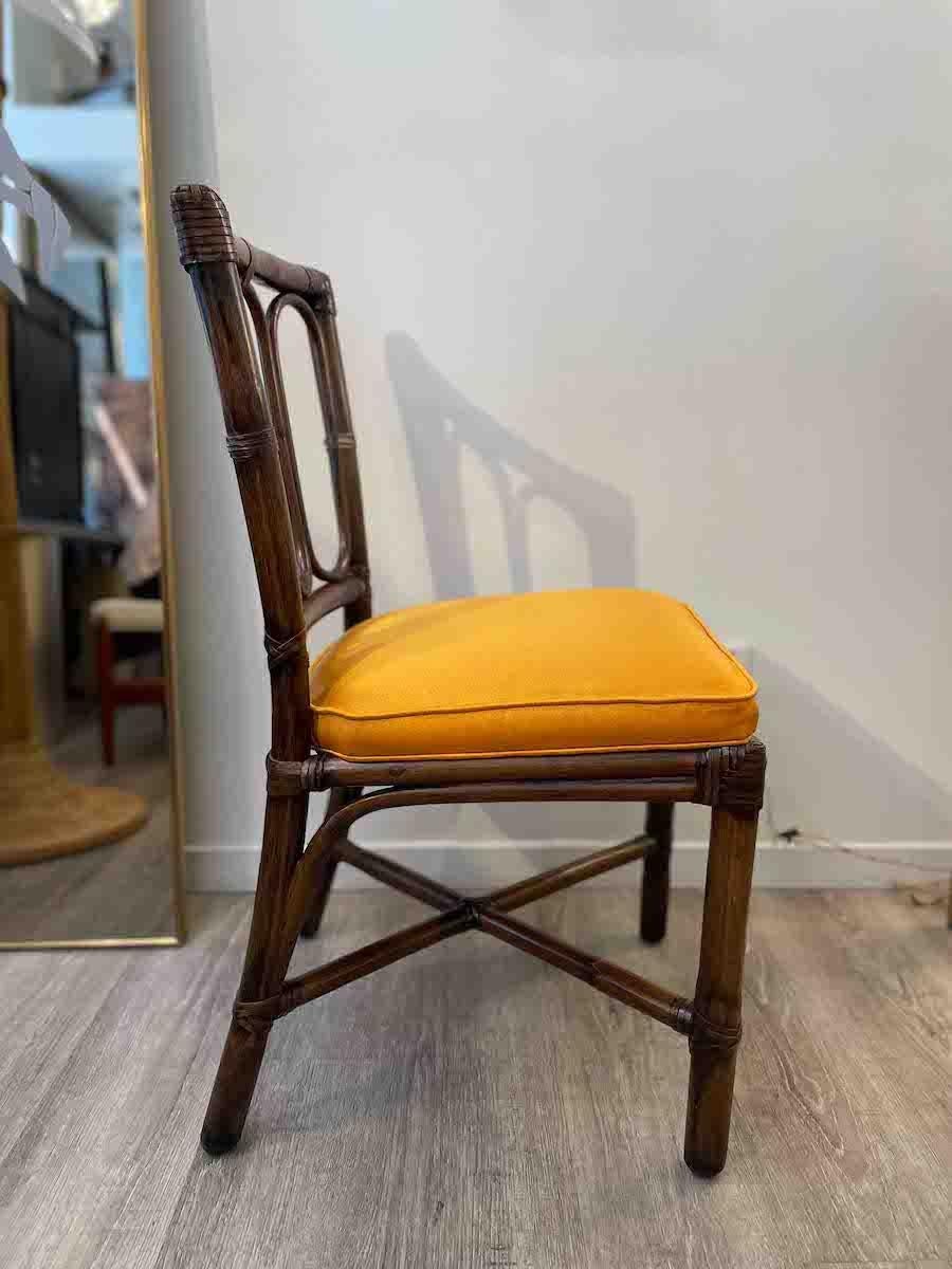 Set di 4 sedie con struttura in bambù e cuscini in seta arancione. 

Le poltrone hanno uno schienale curvo in bambù per creare un comodo supporto per la schiena, restaurato in modo conservativo. La base delle poltrone è realizzata con doghe in legno