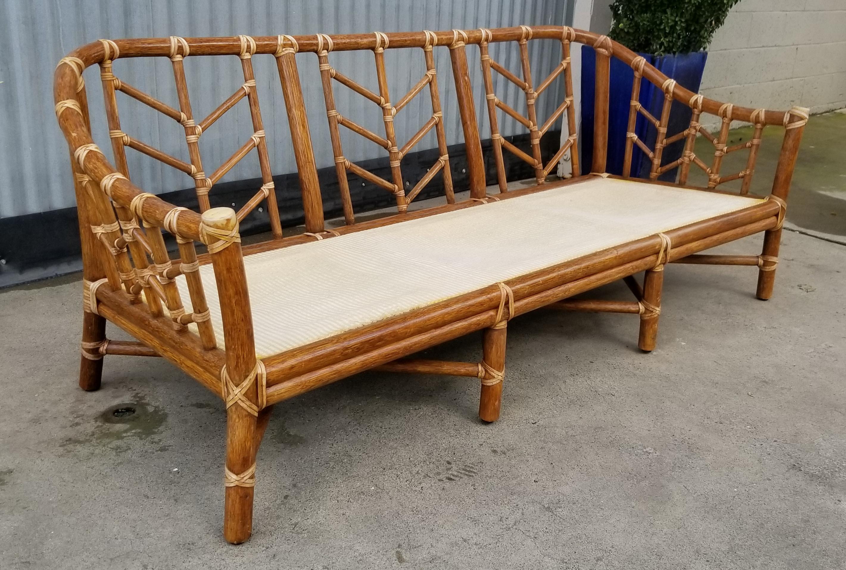 A vintage, organic bamboo / rattan sofa by McGuire Furniture of San Francisco, California. Fine craftsmanship throughout with all leather bindings intact. Frame is structurally very solid. Signed with metal plate and inlay logo. No cushions.