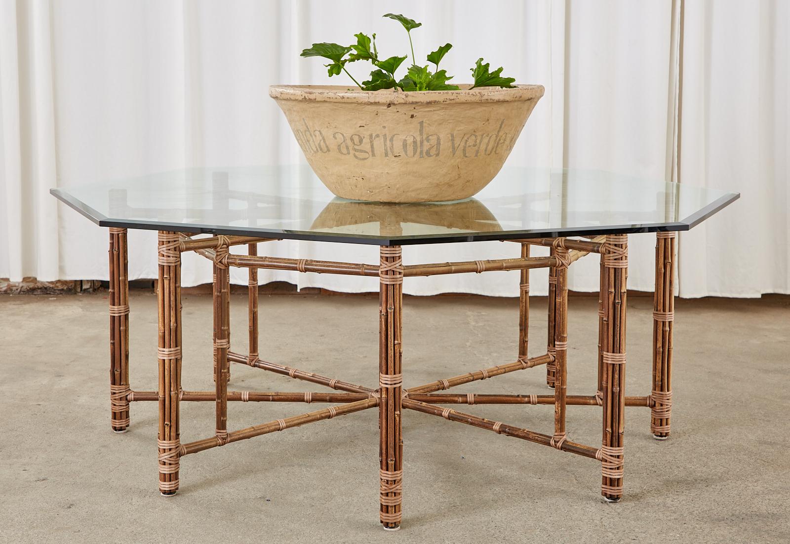 Genuine McGuire bamboo rattan dining table made in the California organic modern style designed by John McGuire. Crafted from an iron skeleton painted golden gate orange for authenticity. The iron base is then covered with rattan poles lashed