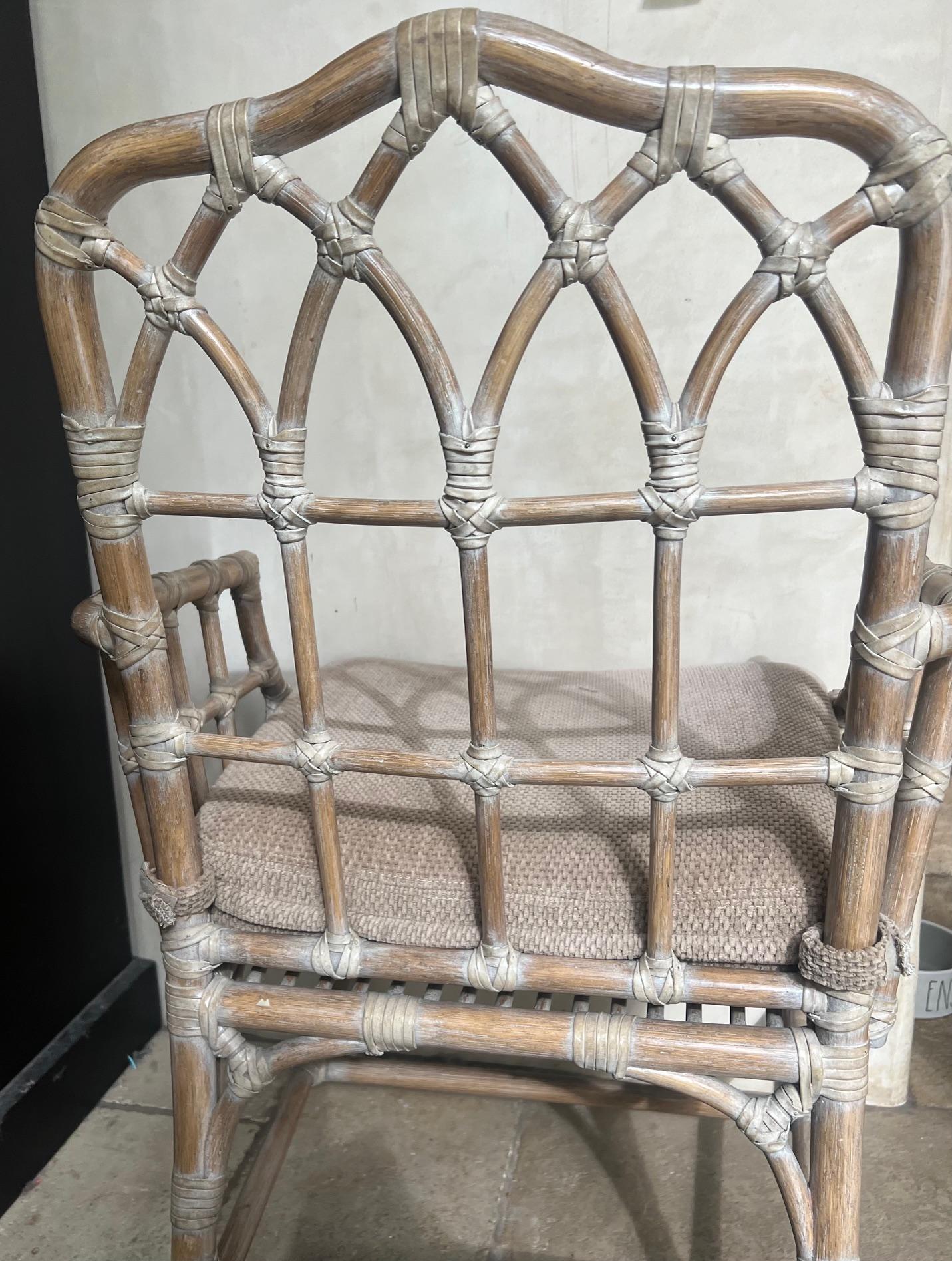 Rattan armchair designed by  Elinor McGuire for McGuire Furniture in San Francisco in 1964. Made in the late 1980's, the design is famous for its rattan cathedral back and McGuire's signature rawhide lacing. The original cerused washed finish are in
