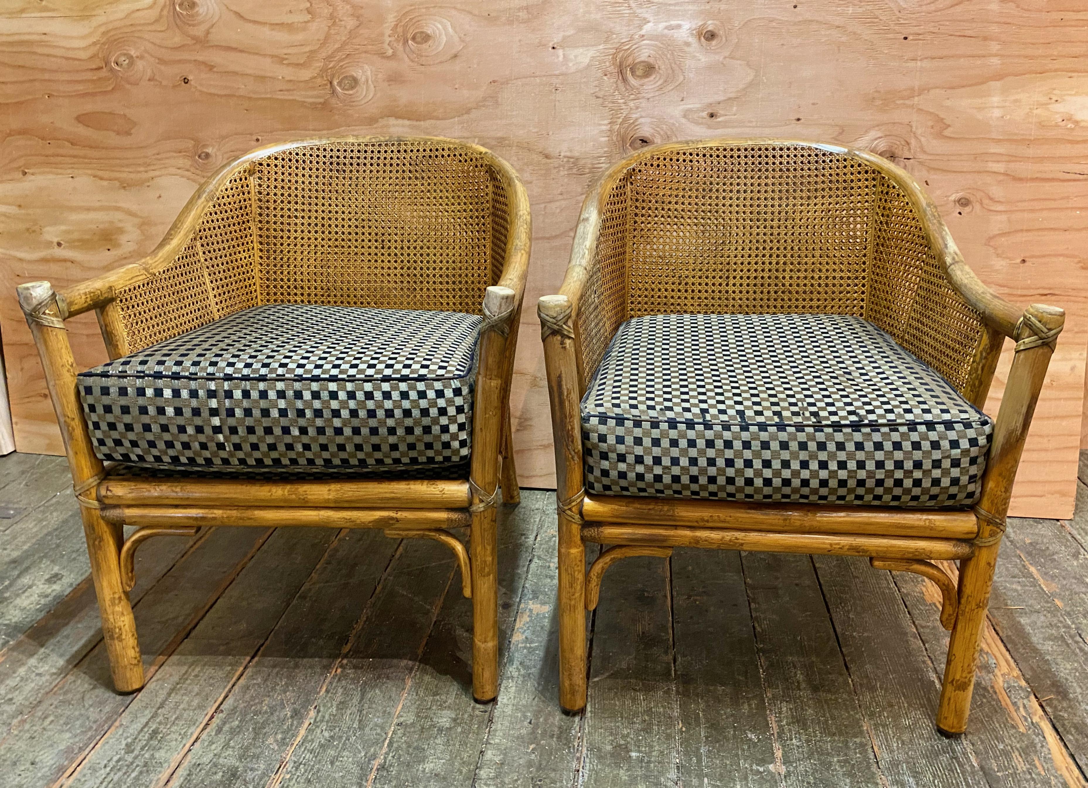 This is a great pair of McGuire Barrel Back arm chairs that feature double cane sides and back with deep seat cushions. These chairs are a good representation of Coastal Style with their bamboo frames, chinoiserie influence and quality caning. The