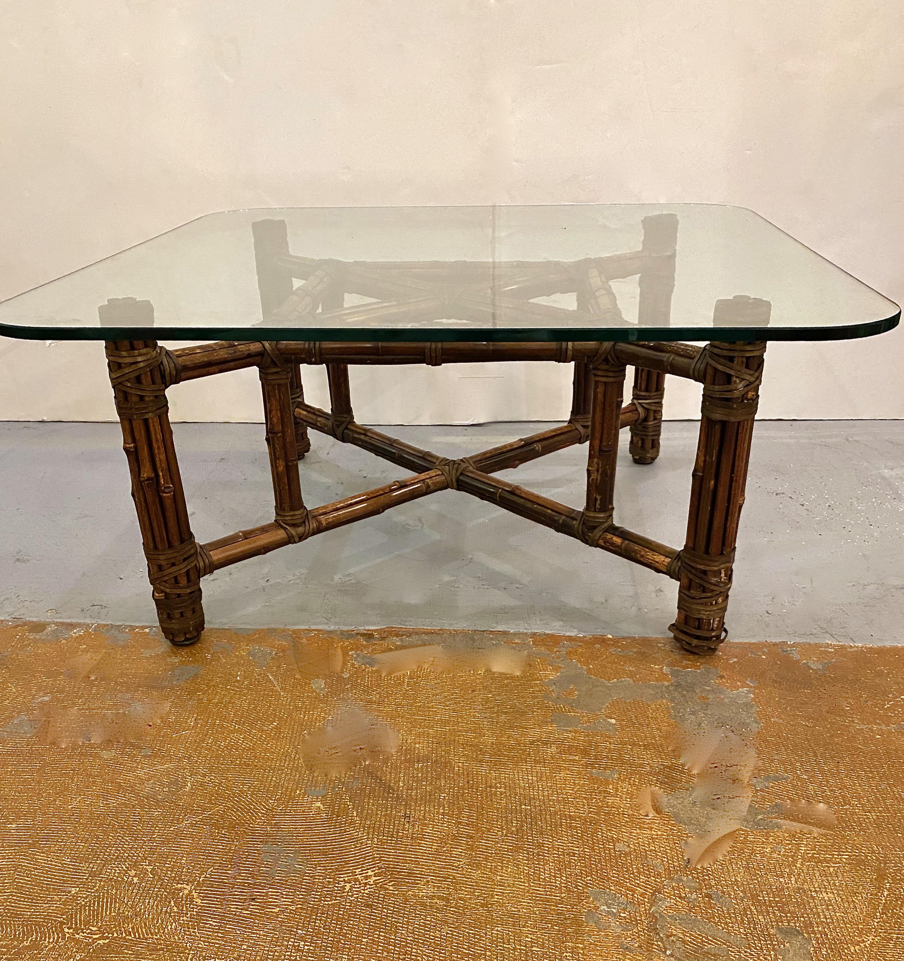 This is a charming McGuire-attributed small coffee table. All design details conform to McGuire tables, but this table does not retain a McGuire tag. The table is in very good original condition. The replaced glass top is of the highest quality