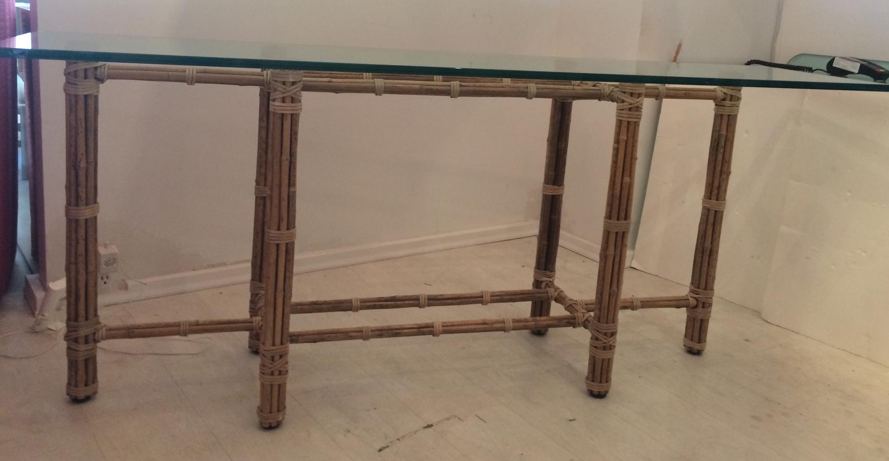 McGuire console table made from rattan and split Bamboo with steel reinforced frame. Glass top table. Both glass and table are in very good original condition. McGuire furniture is made to last a life time. Chinese Chippendale style.