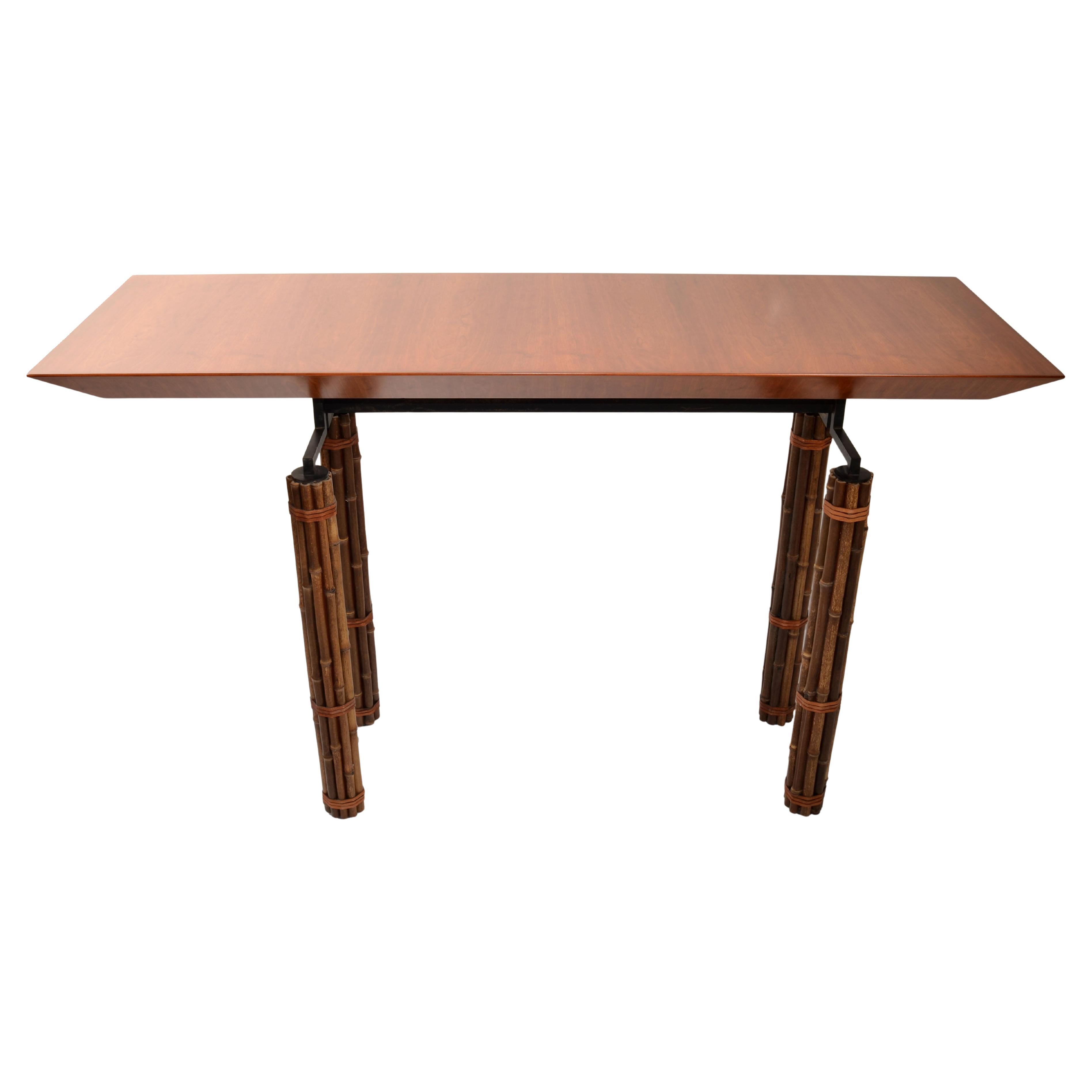 Mid-Century Modern Bohemian Chic McGuire Console Table, Hallway Table or Sofa Table.
Features a floating restored Cherry Wood Top combined with faux bamboo legs and rawhide decor, mounted on a firm iron Base.
The Huxley Series was designed by