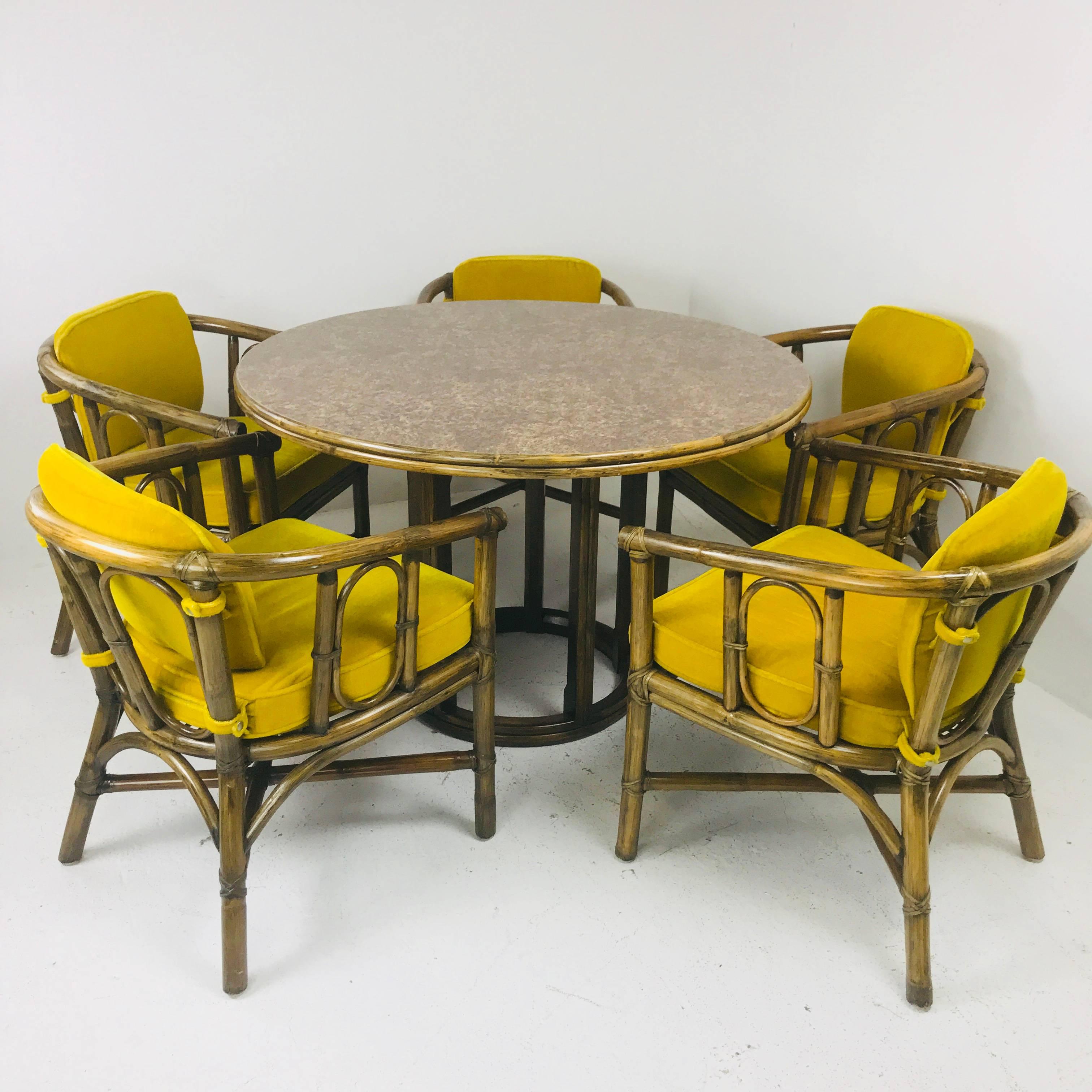 McGuire dining set with five chairs and round table with laminate top. Dining set is in nice vintage condition with wear due to use and age. New finish and upholstery is recommended but can be used as is.

Dimensions:
25