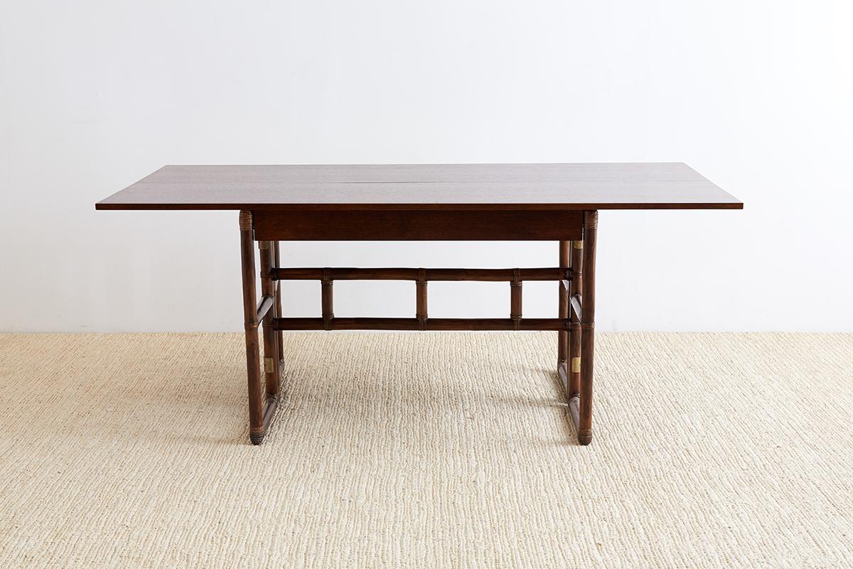 Mid-Century Modern style flip top server or console table that could also be used as a dining table. Produced by McGuire from oak with a rattan base that is reinforced with leather rawhide strapping. Fronted by a large 37 inch drawer for storage