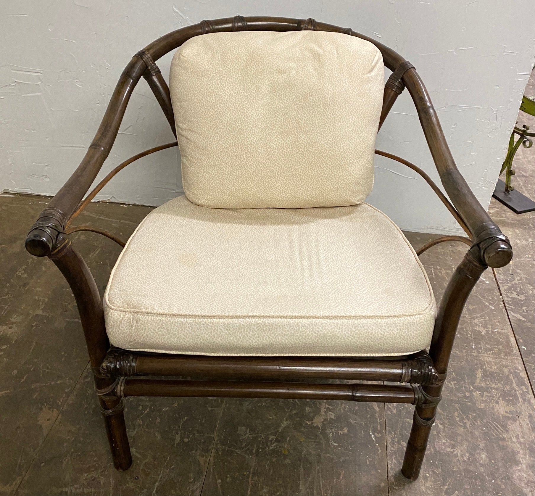Stylish and elegant, the McGuire organic modern horseshoe rattan armed club chair with partial gilt finish is a classic. The rattan frame is reinforced with leather rawhide laces on the exposed joint. The chair has a loose back and seat cushions.